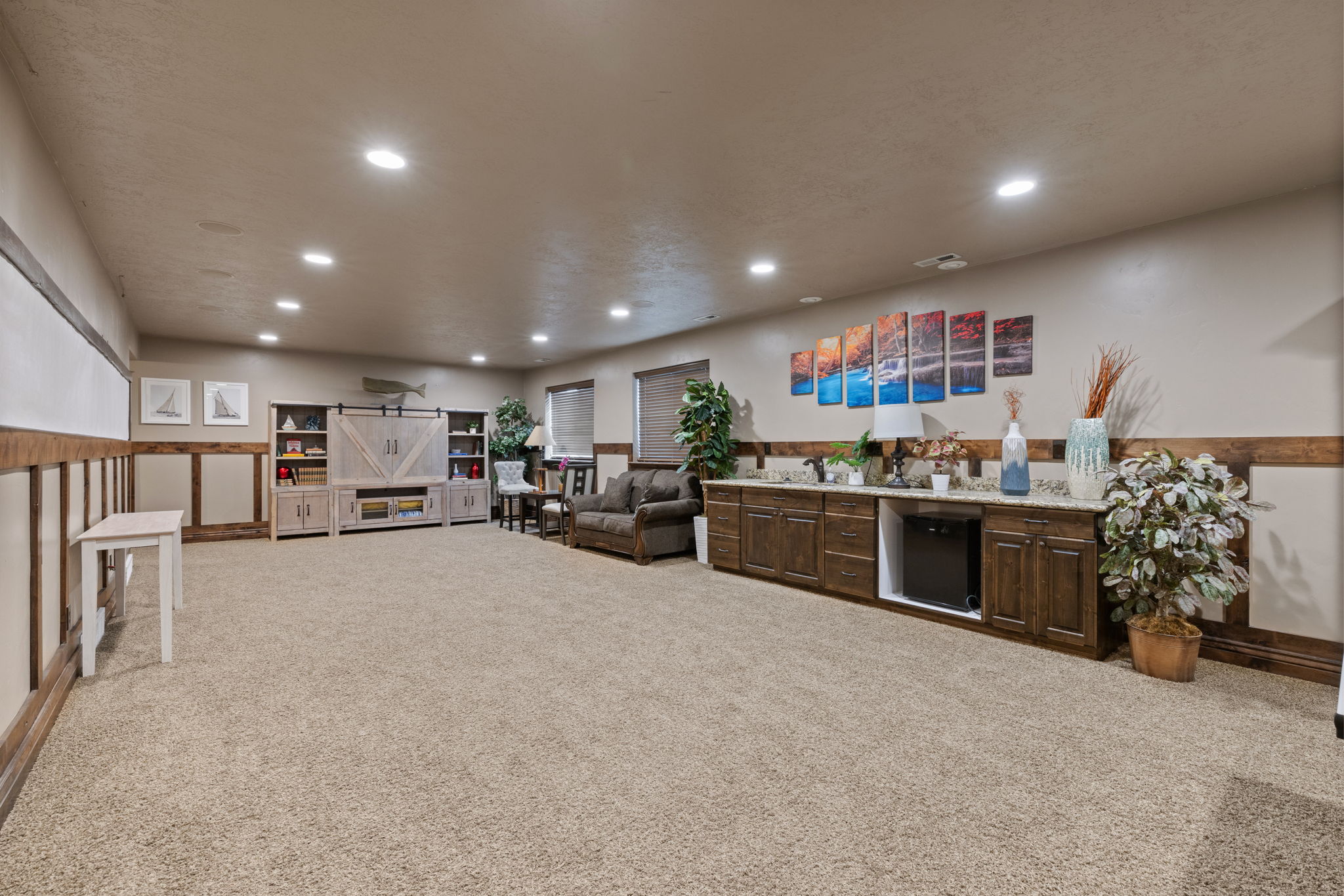 Spacious room featuring broadloom carpet, recessed lighting, and wainscoting with wood trim