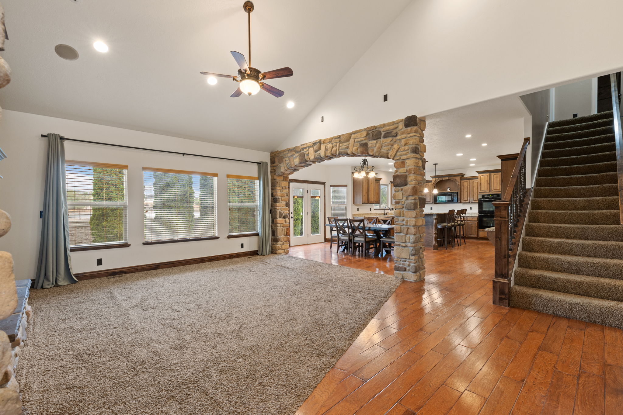Expansive living area featuring vaulted ceilings, recessed lighting, and large windows