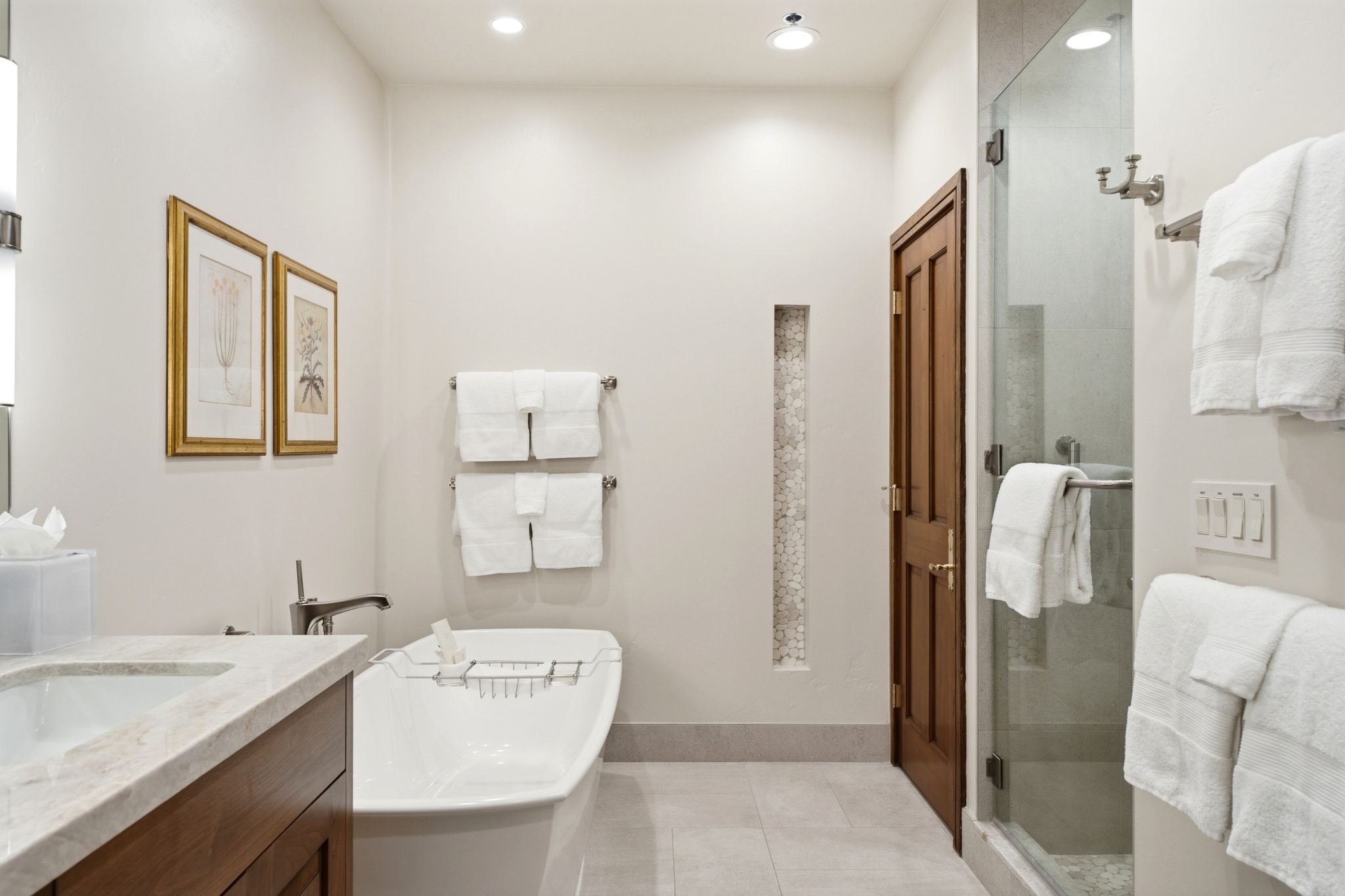 Bathroom featuring a freestanding soaking tub, glass-enclosed shower, single vanity with light-toned countertop, recessed lighting, and tile flooring