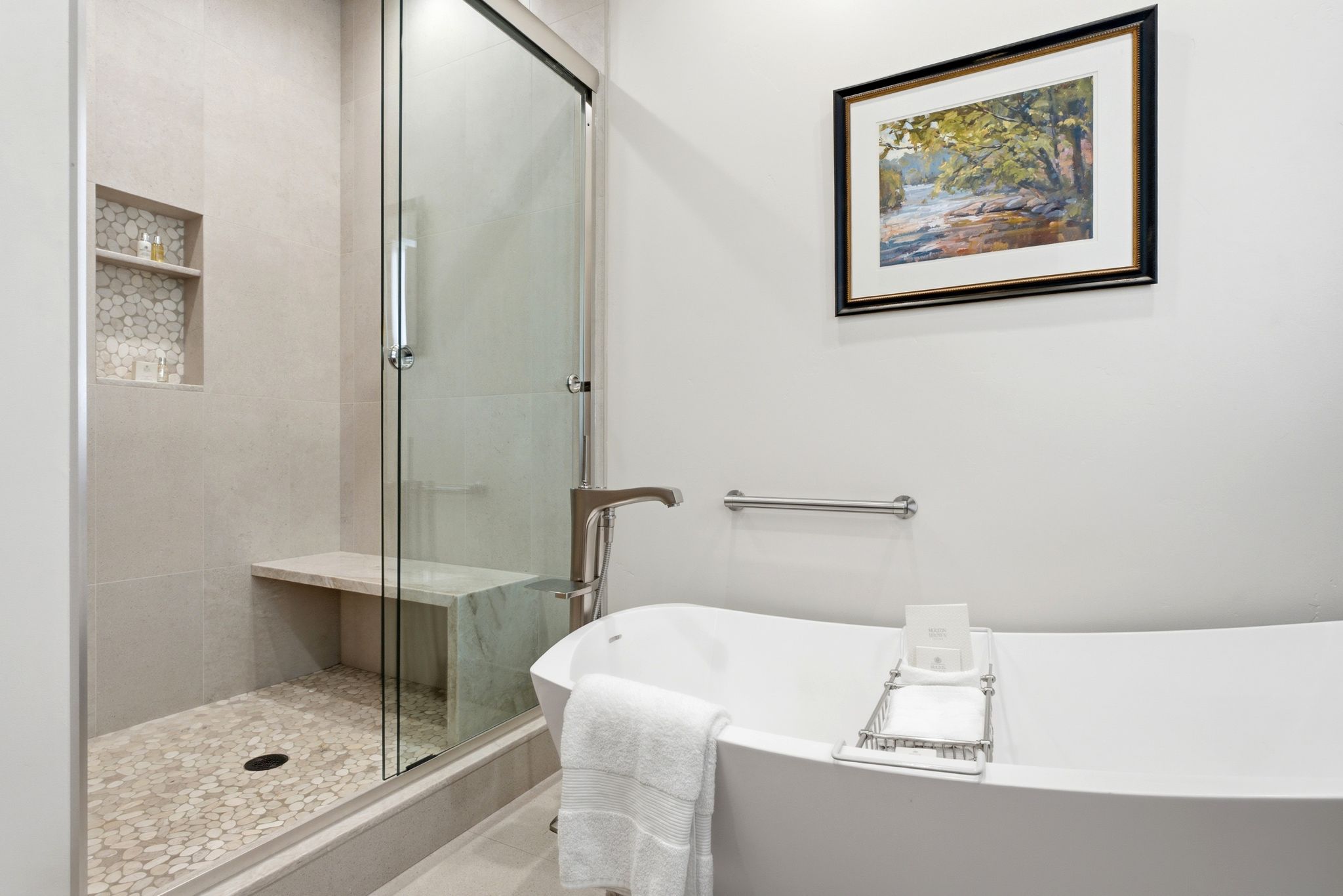 Freestanding soaking tub alongside a walk-in shower with a glass enclosure