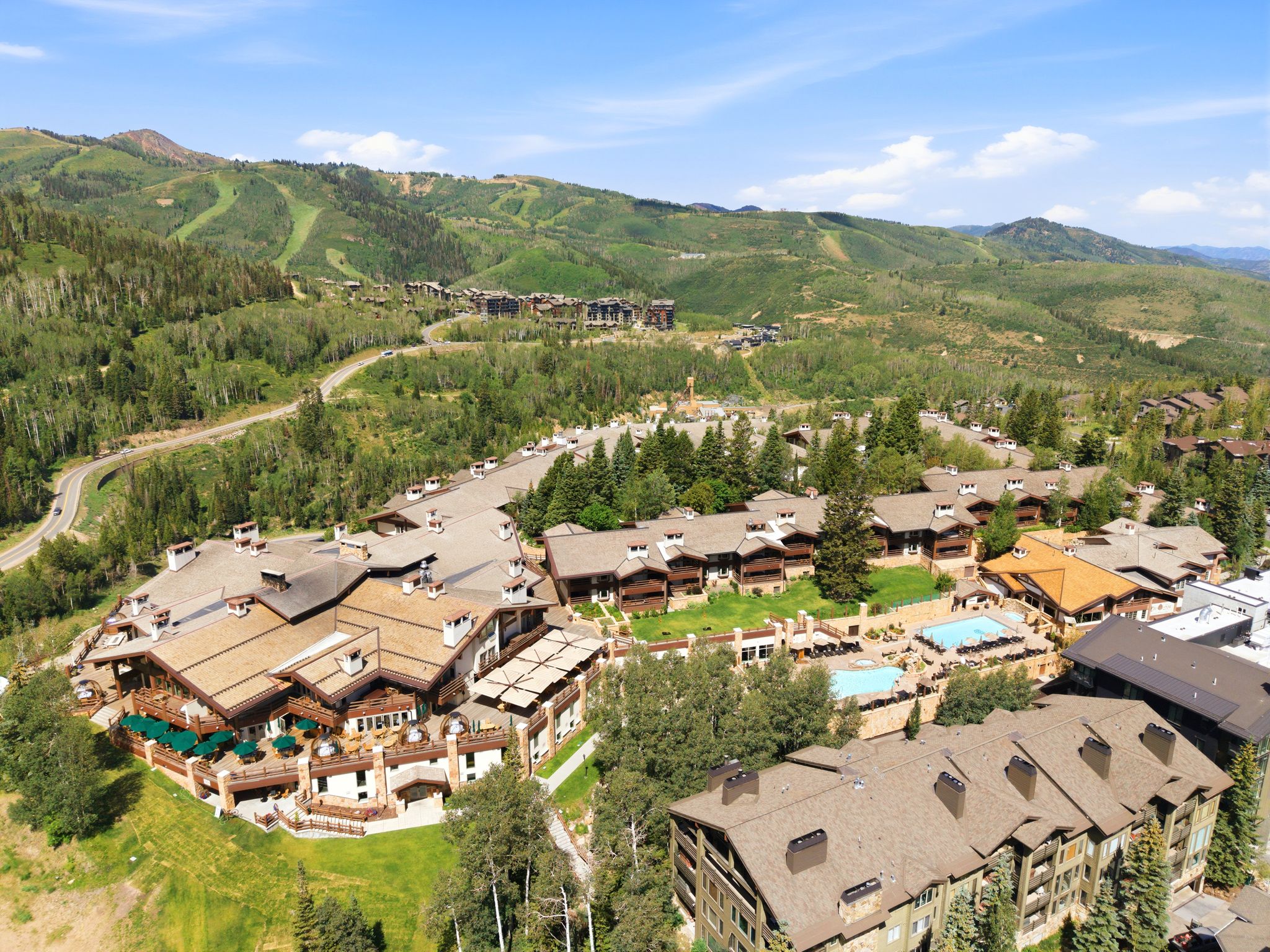 Large-scale mountain resort community featuring extensive pitched roofs, multiple outdoor swimming pools, and numerous balconies