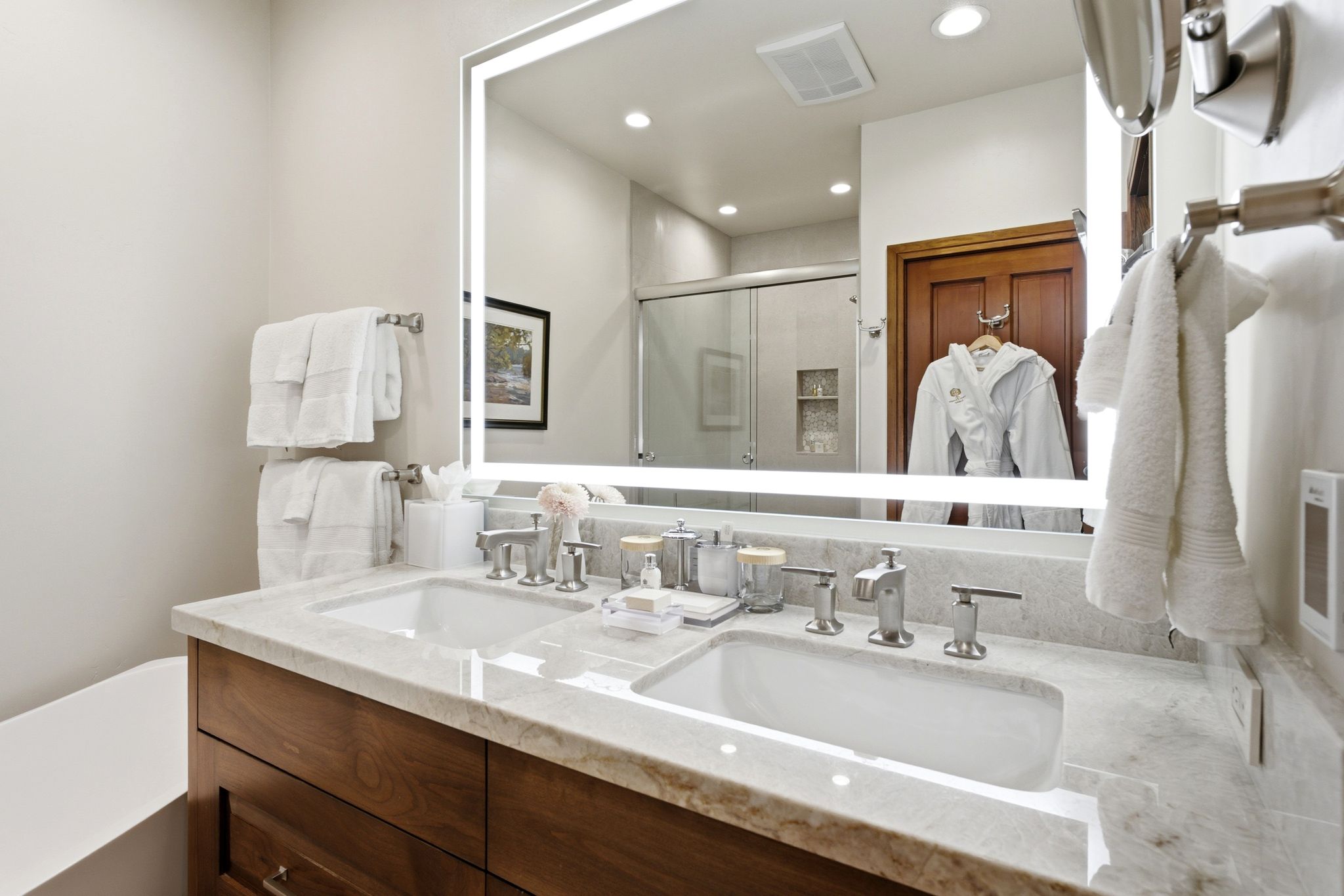 Dual undermount sinks set into a light-toned stone countertop, complemented by brushed nickel fixtures