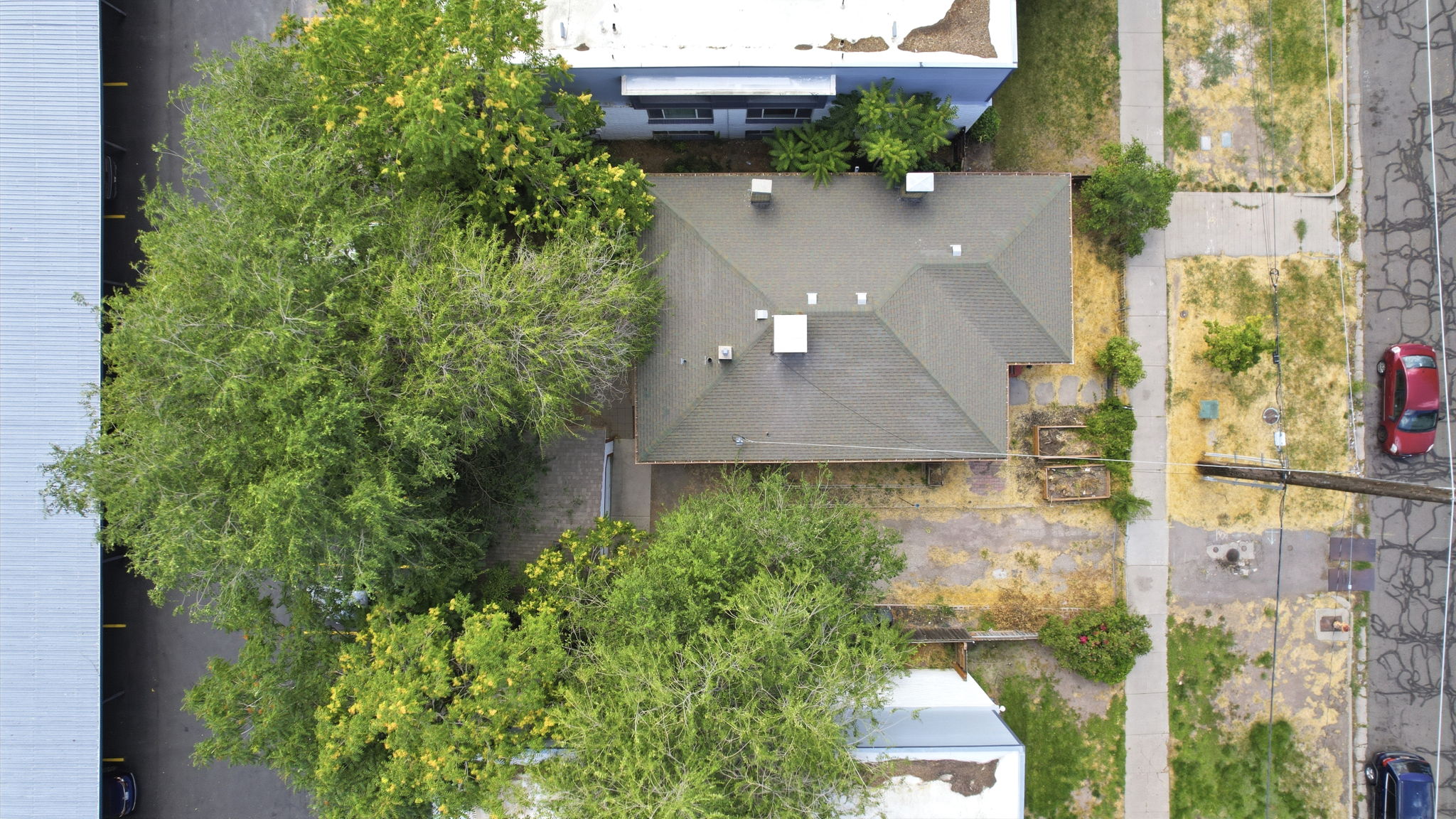 Hip roof property with mature trees and a paved driveway