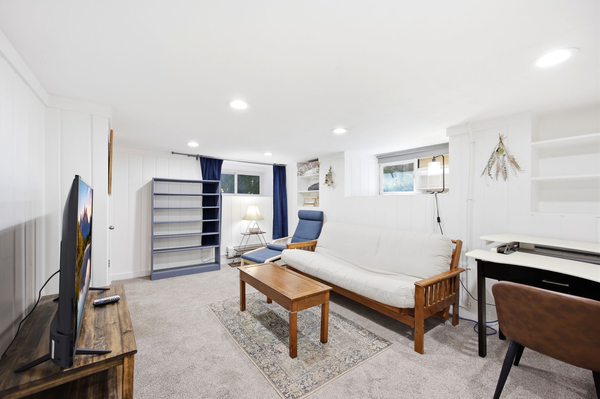 Versatile lower-level room featuring plush carpeting, recessed lighting, and white paneled walls