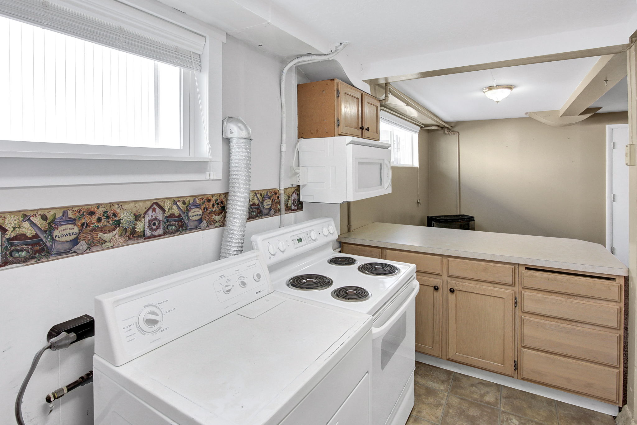 Laundry area featuring a washer, dryer, built-in cabinetry, and a microwave