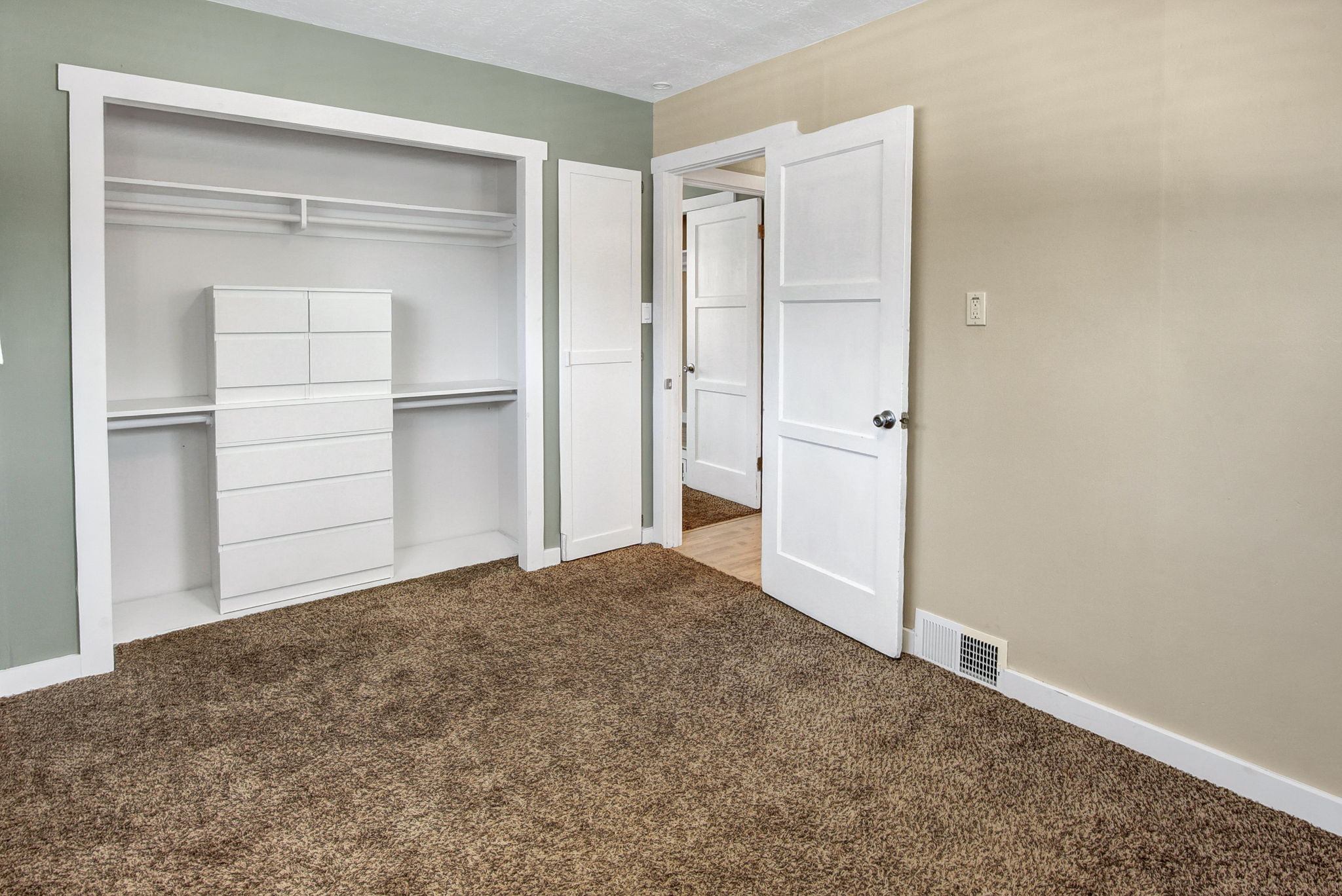 Bedroom featuring a built-in closet with shelving and hanging rods