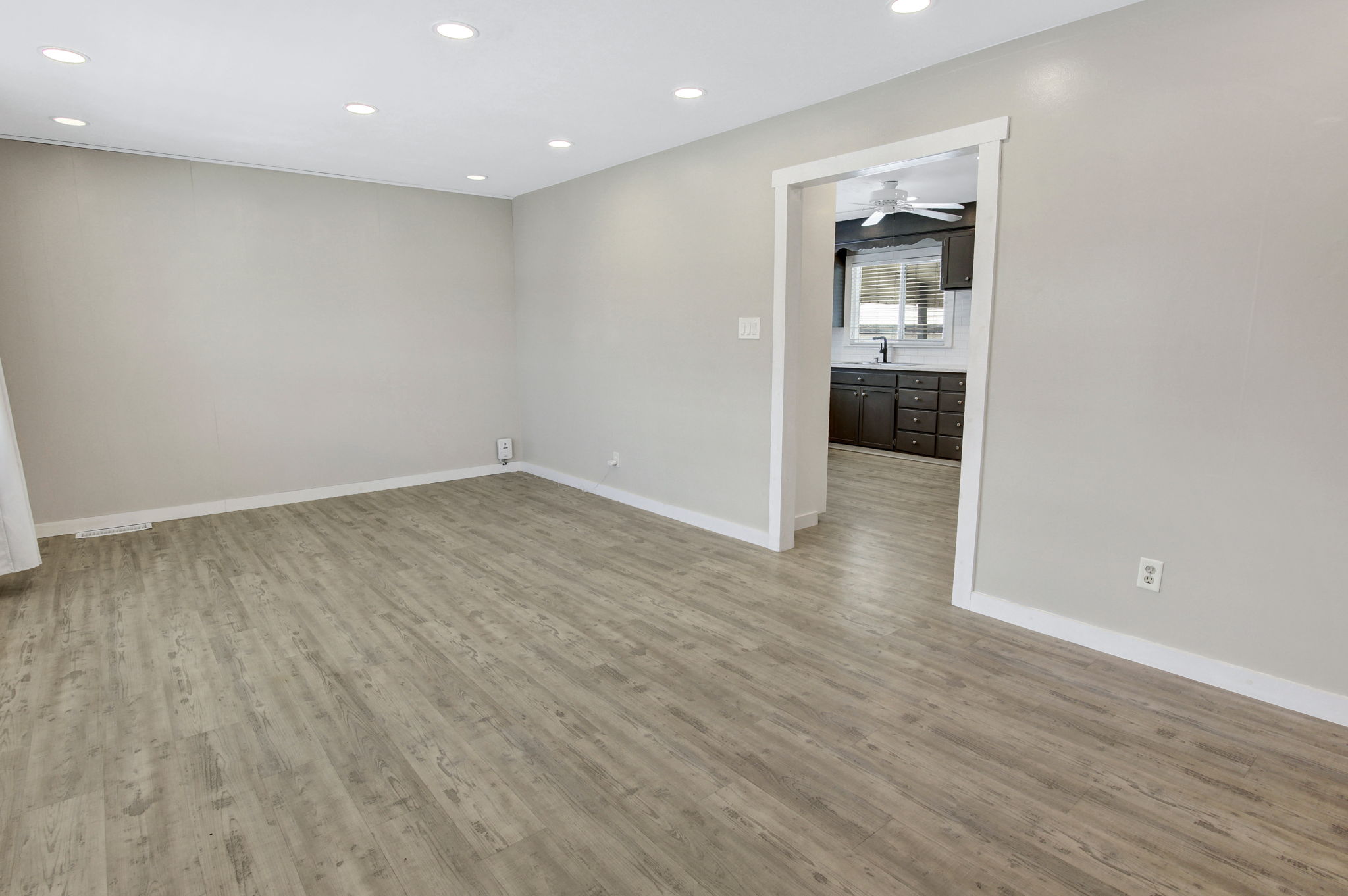 Open-concept living area with recessed lighting, light wood-finish flooring, and a neutral color palette