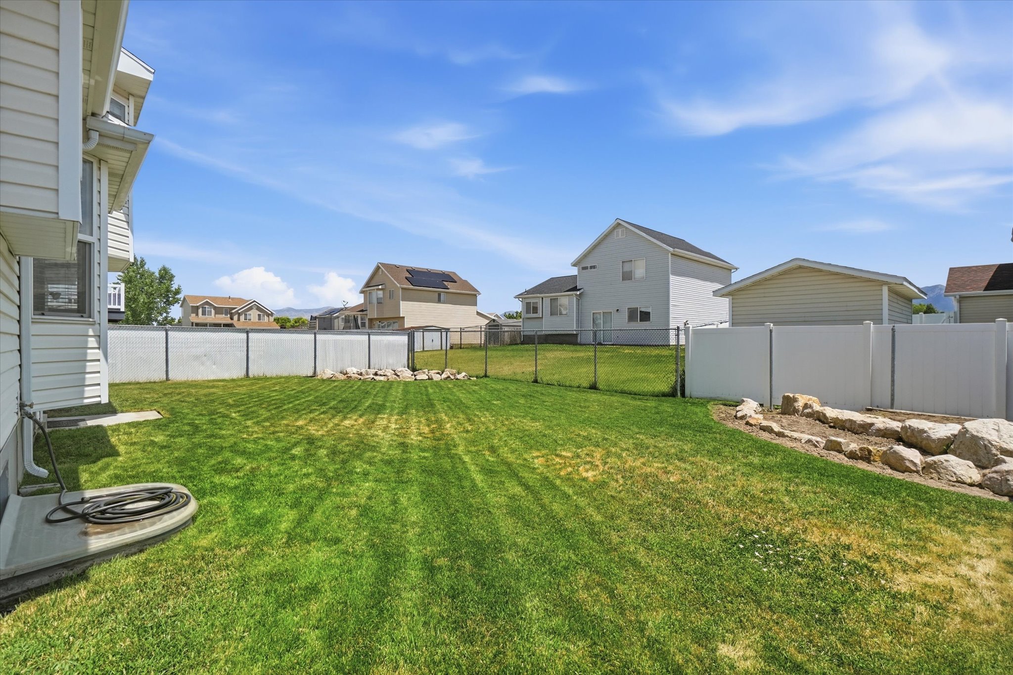 Expansive green lawn with a fully fenced backyard
