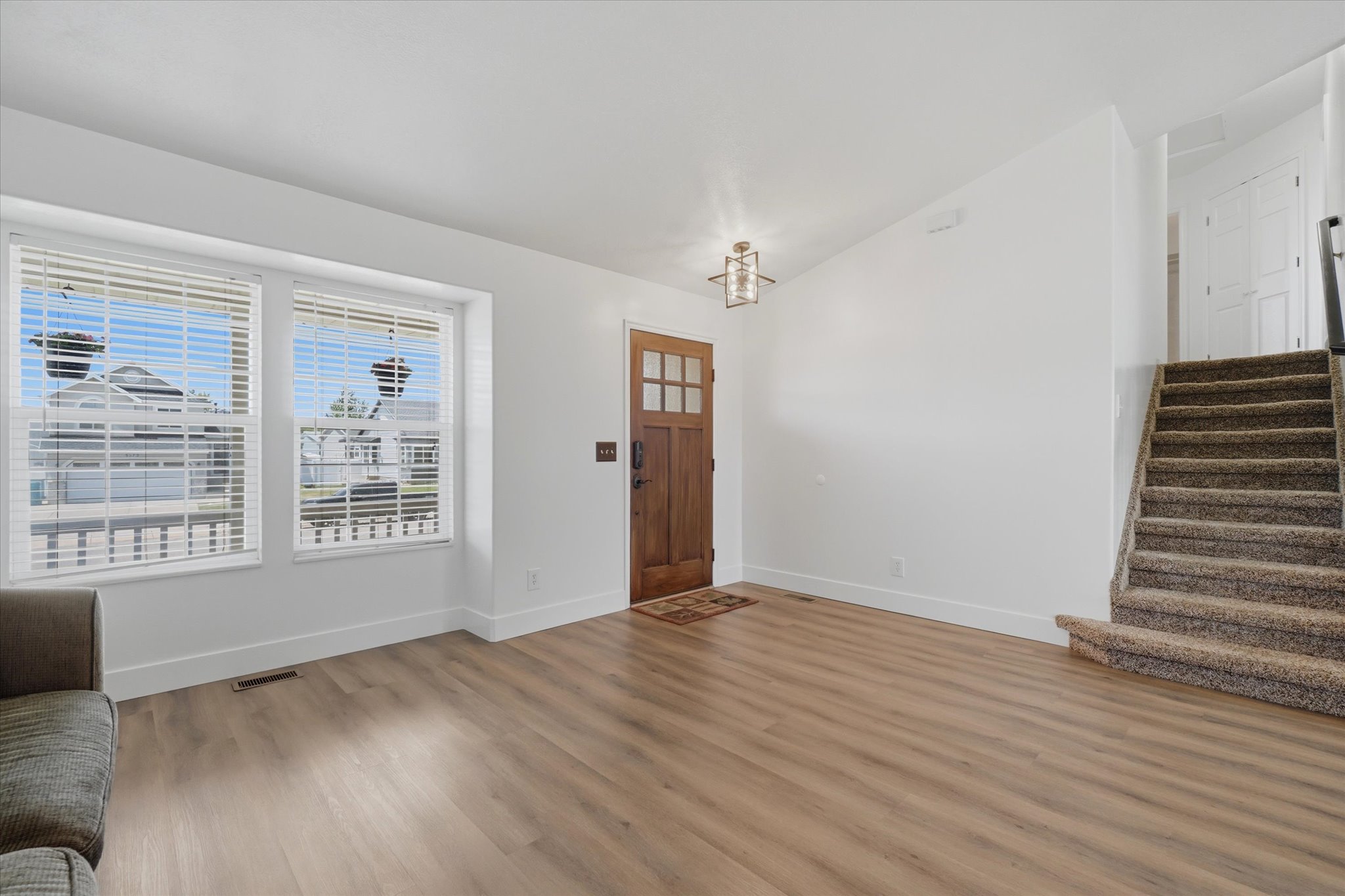 Living Room, LVP flooring, front door and window and stairs to second level
