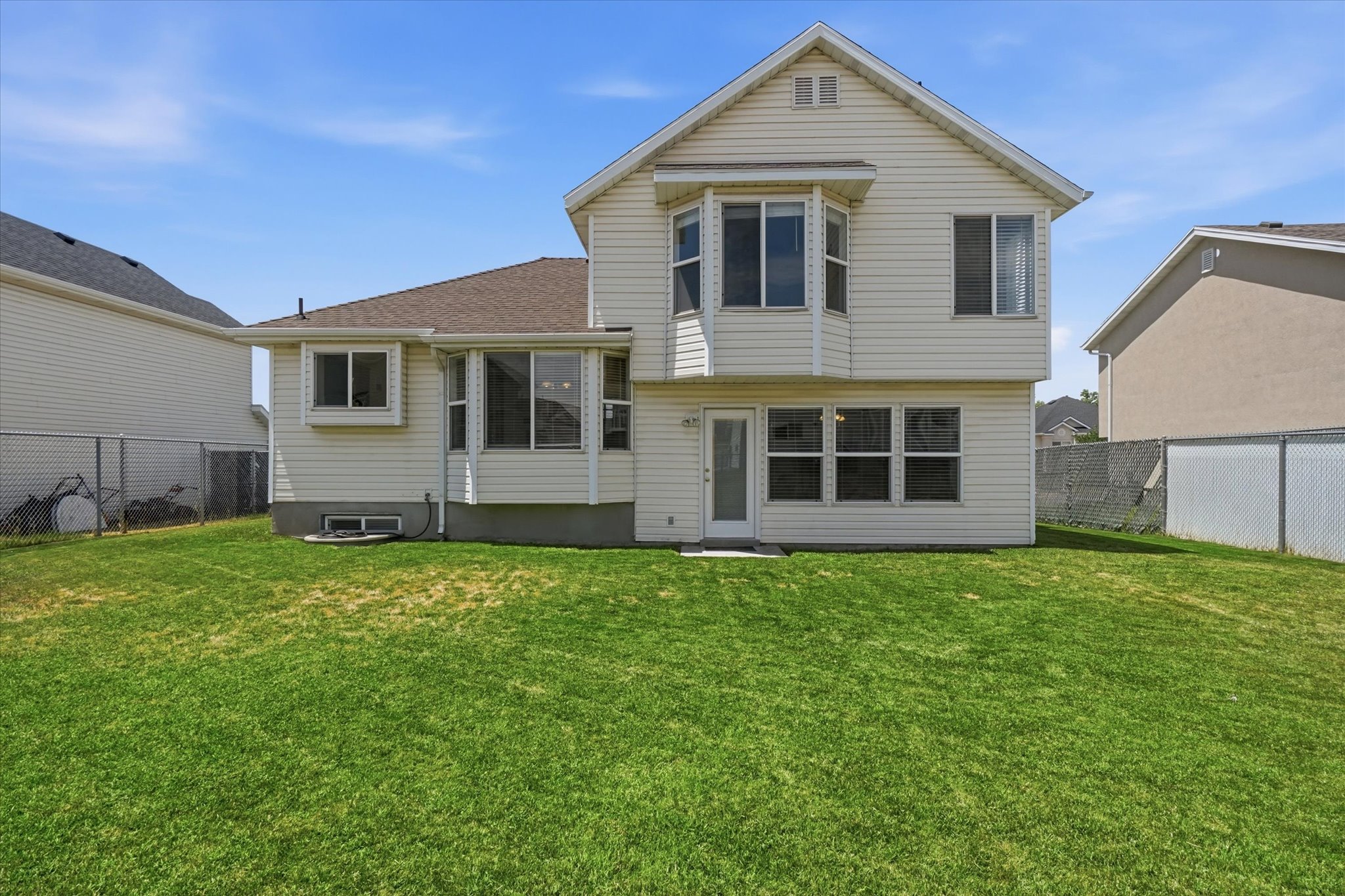 Rear exterior with light-colored siding and a bay window feature