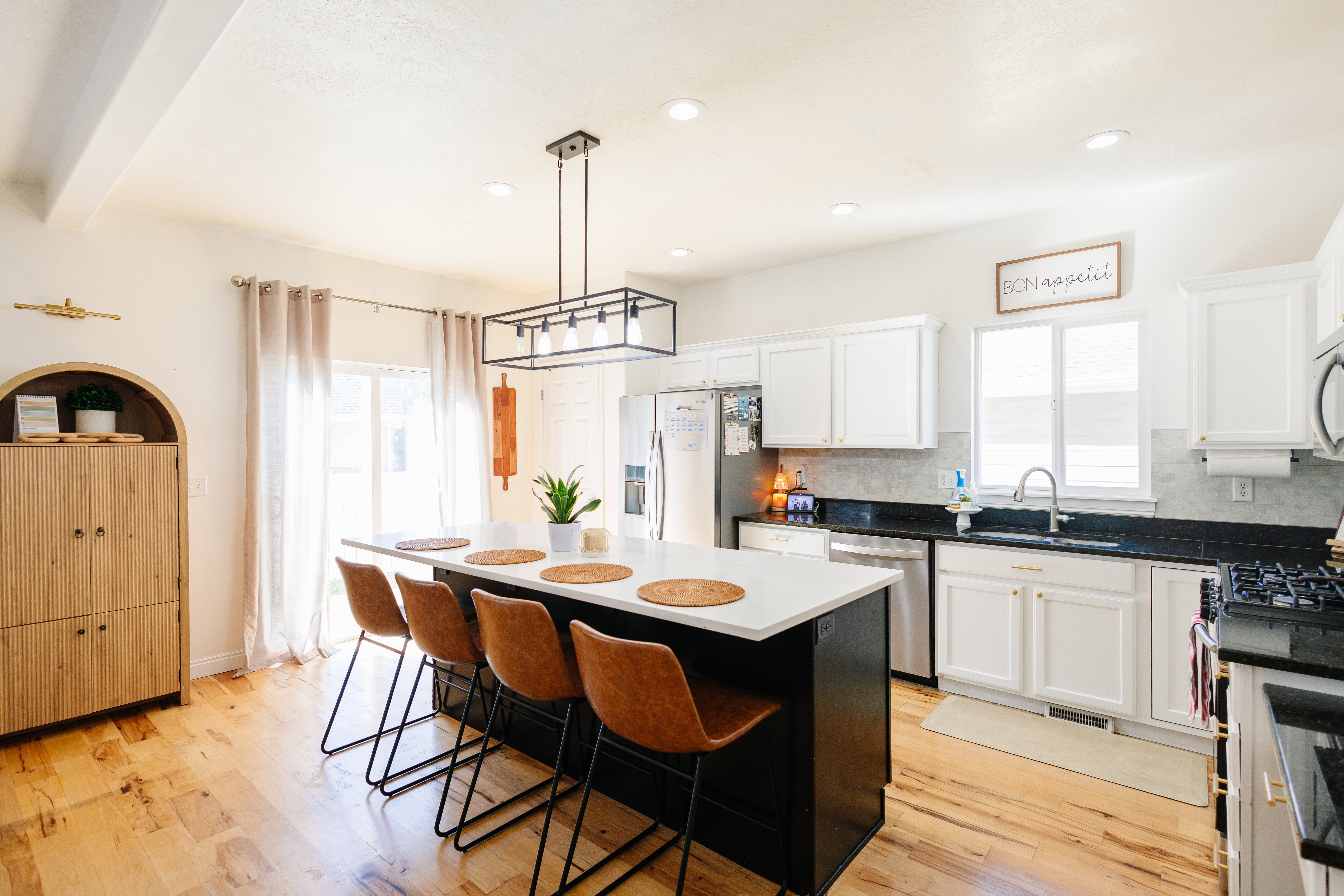 Contemporary kitchen featuring wood-finish flooring, a central island with a white countertop, white cabinetry, and recessed lighting