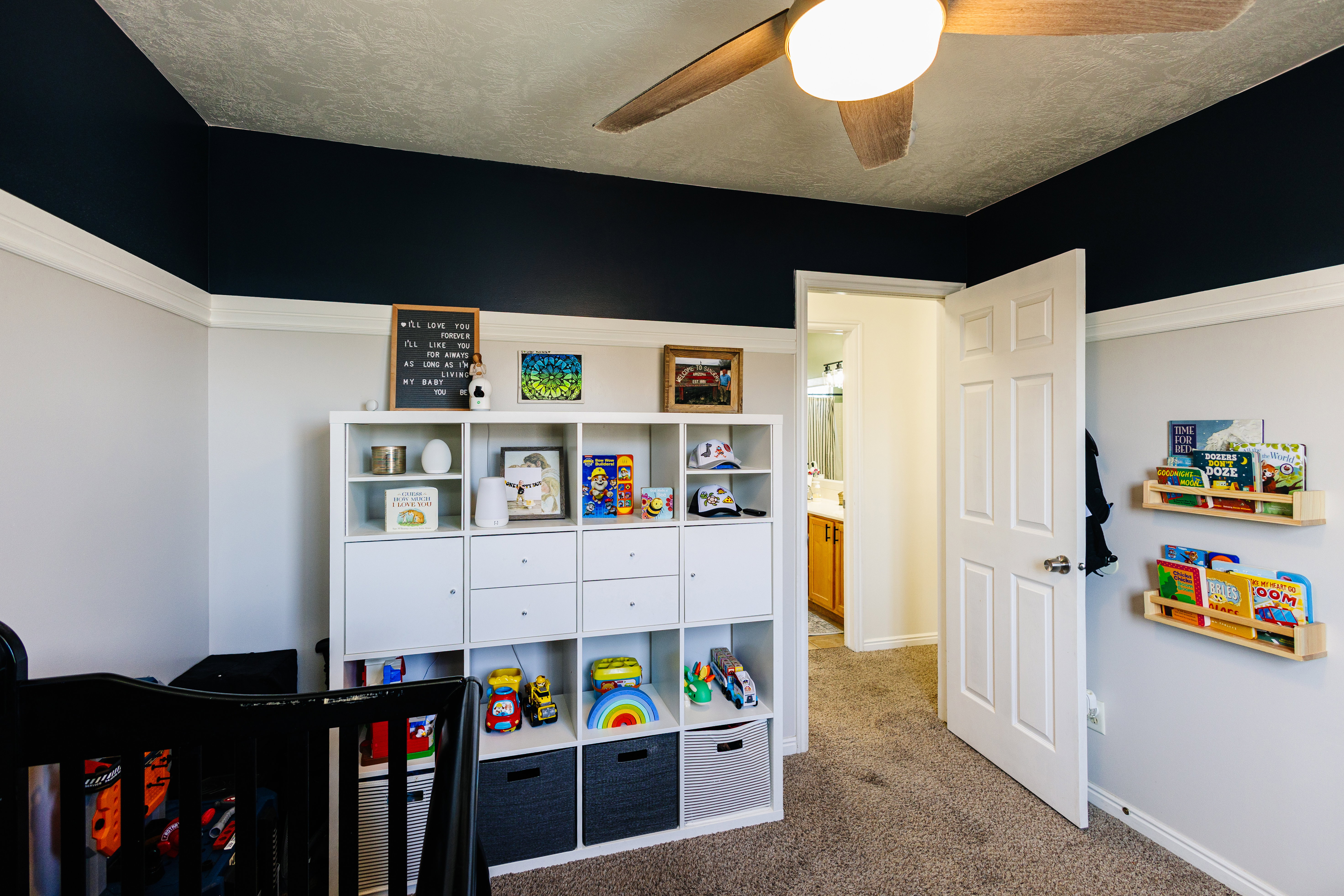 Bedroom featuring two-tone walls with crown molding, textured ceiling, and a ceiling fan with integrated lighting