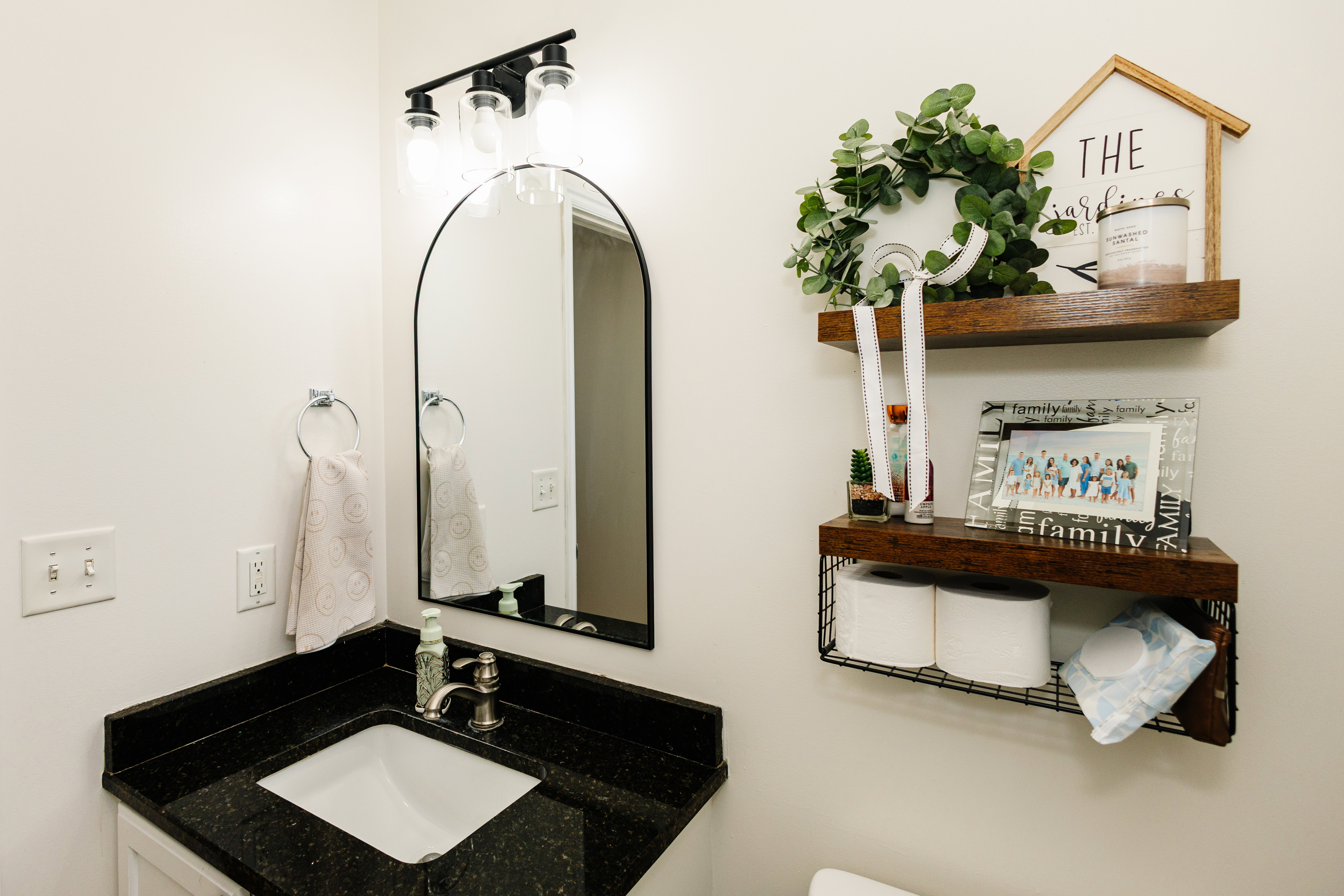 Bathroom vanity featuring a black granite countertop and undermount sink