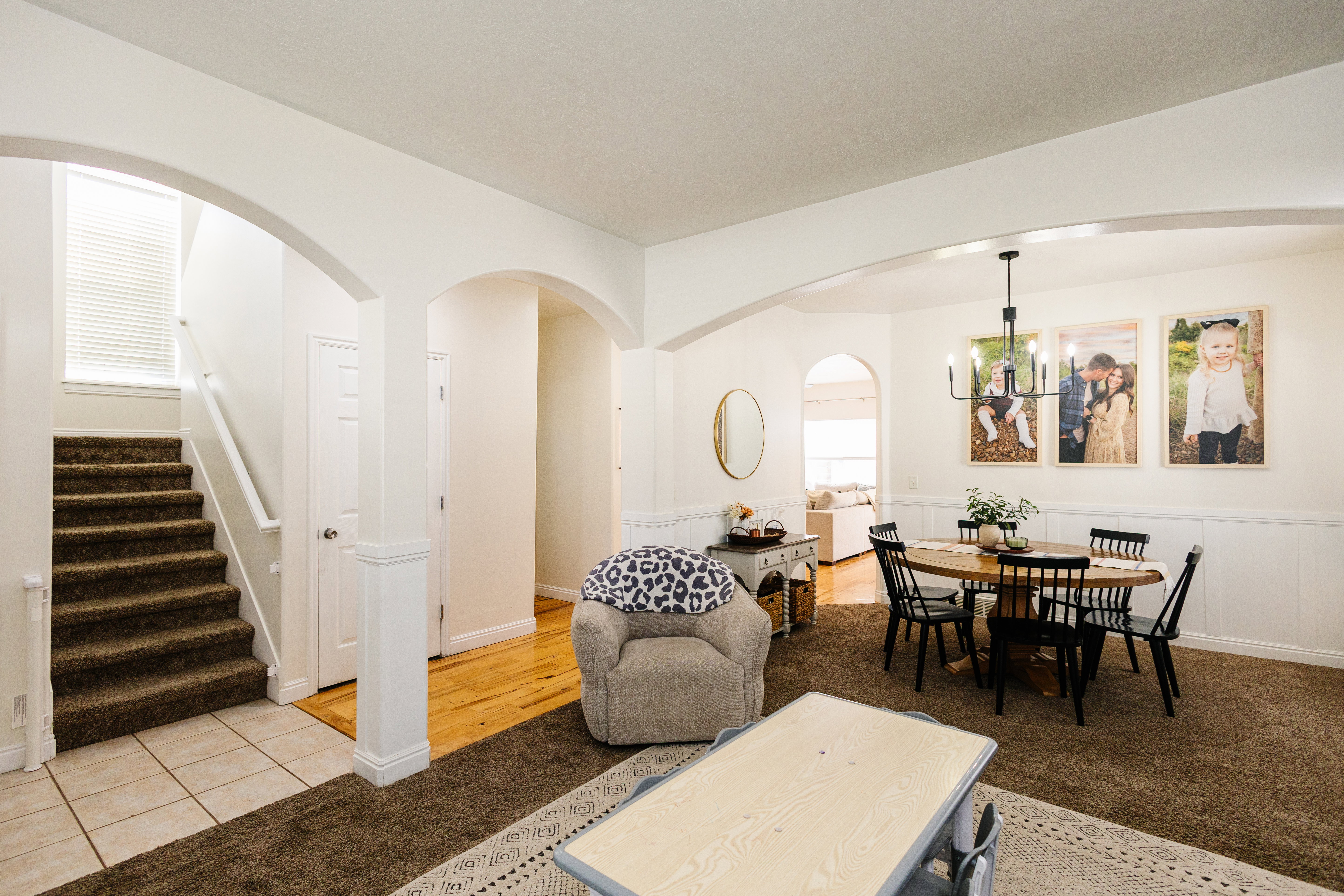 Spacious interior featuring arched doorways, wainscoting, and a multi-light chandelier