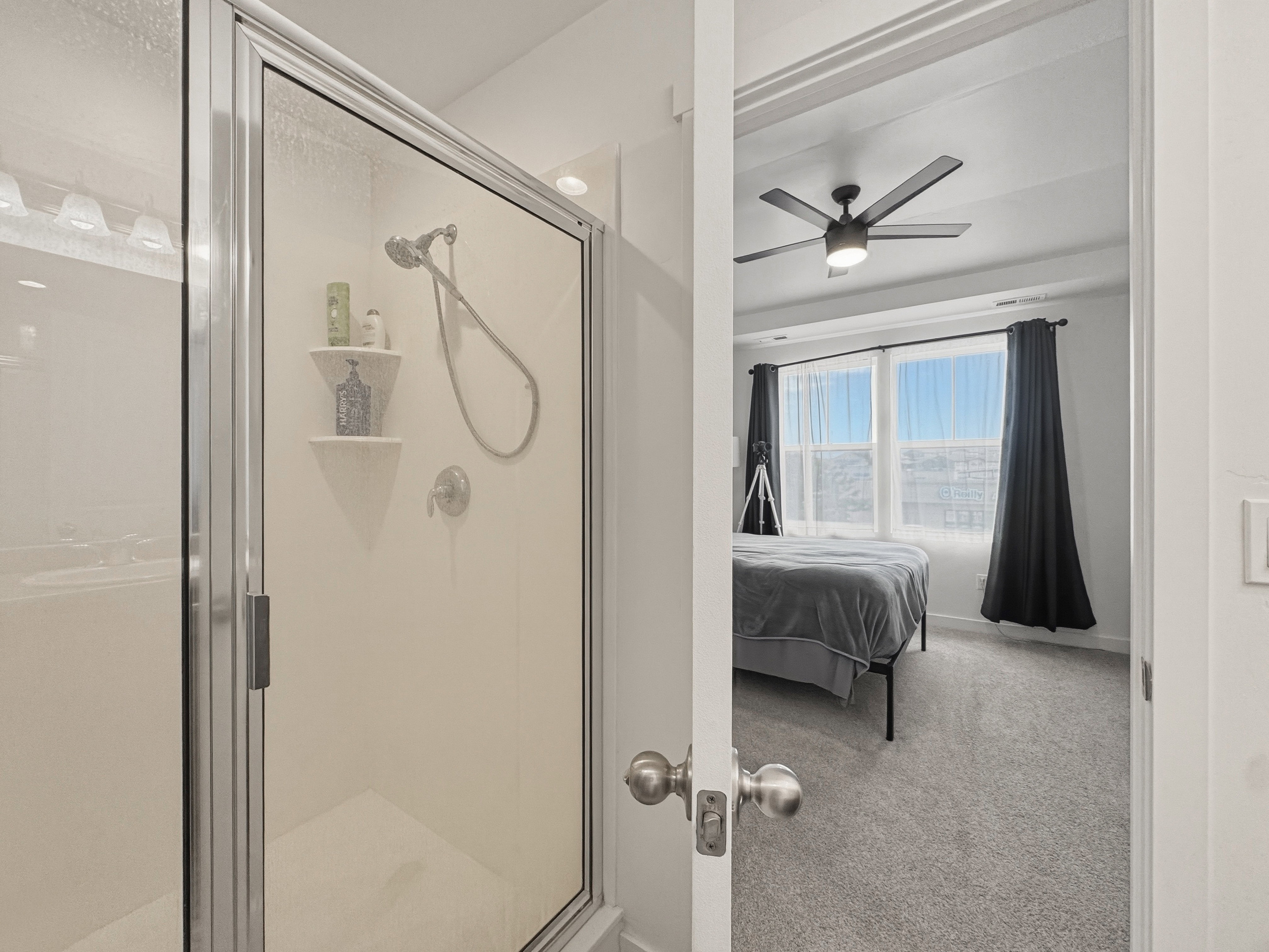 Glass-enclosed shower with chrome fixtures and built-in shelving