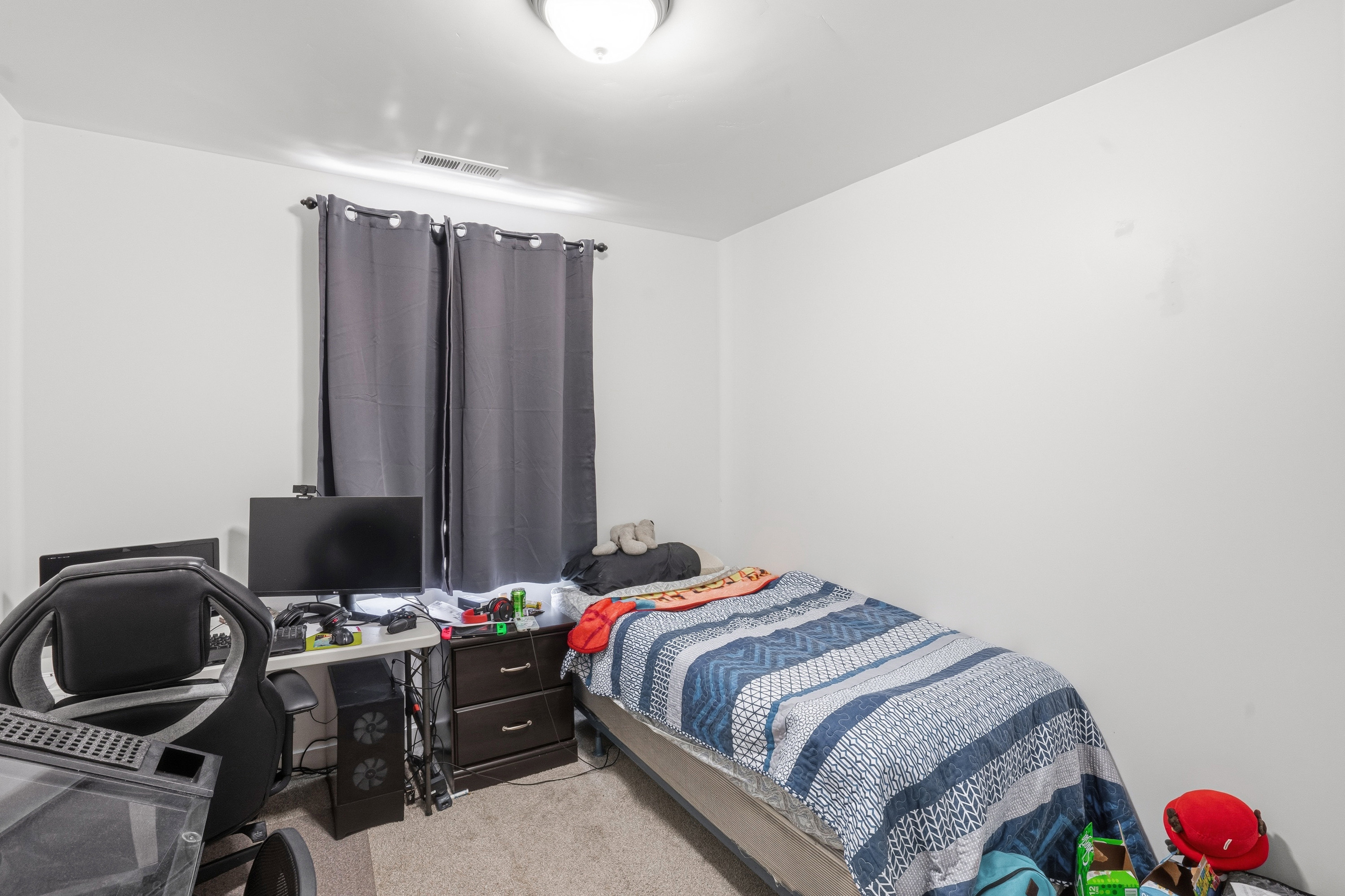Bright room featuring light-colored walls and neutral carpeting