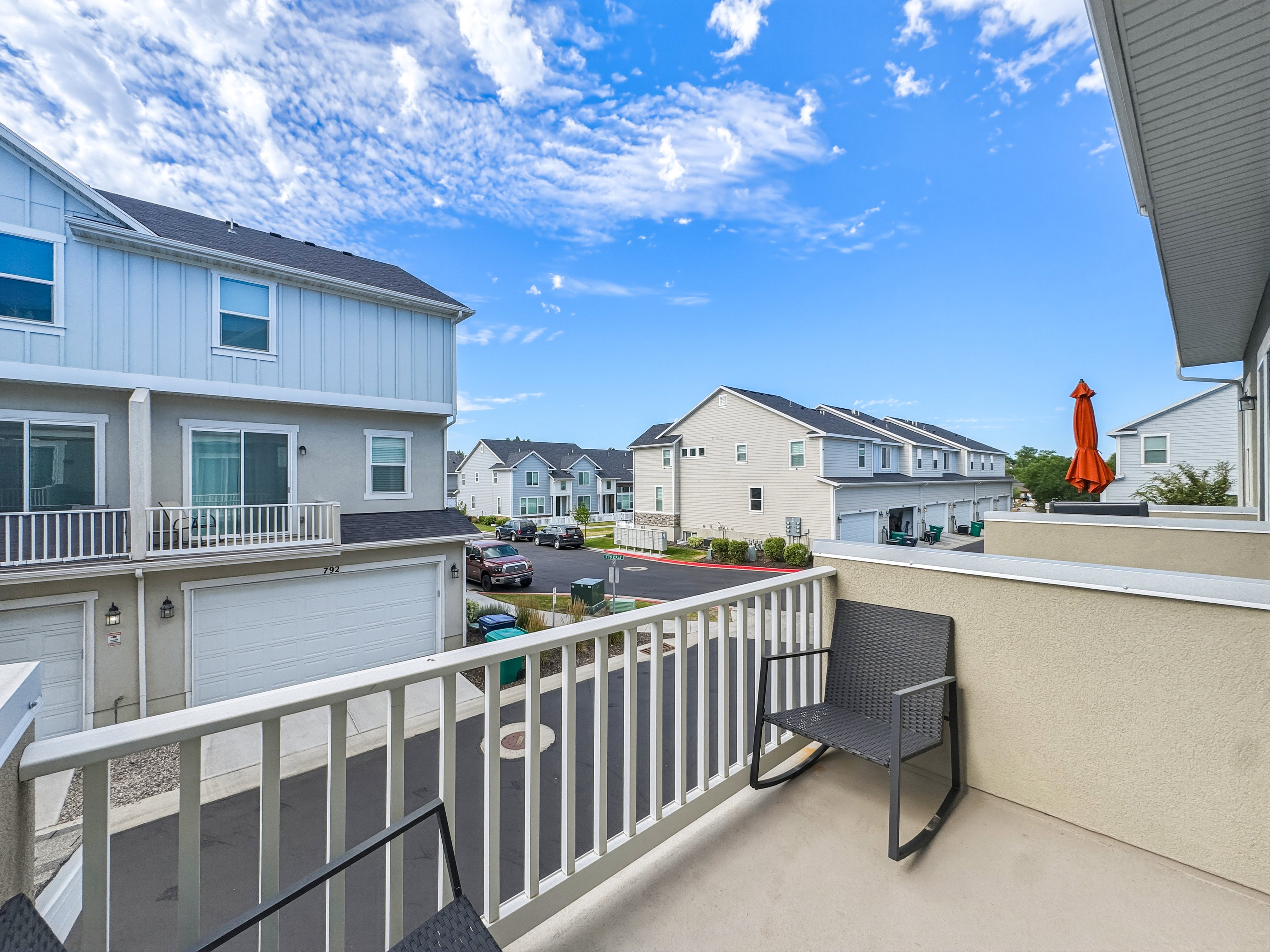 Private balcony featuring a stucco exterior wall and white railing