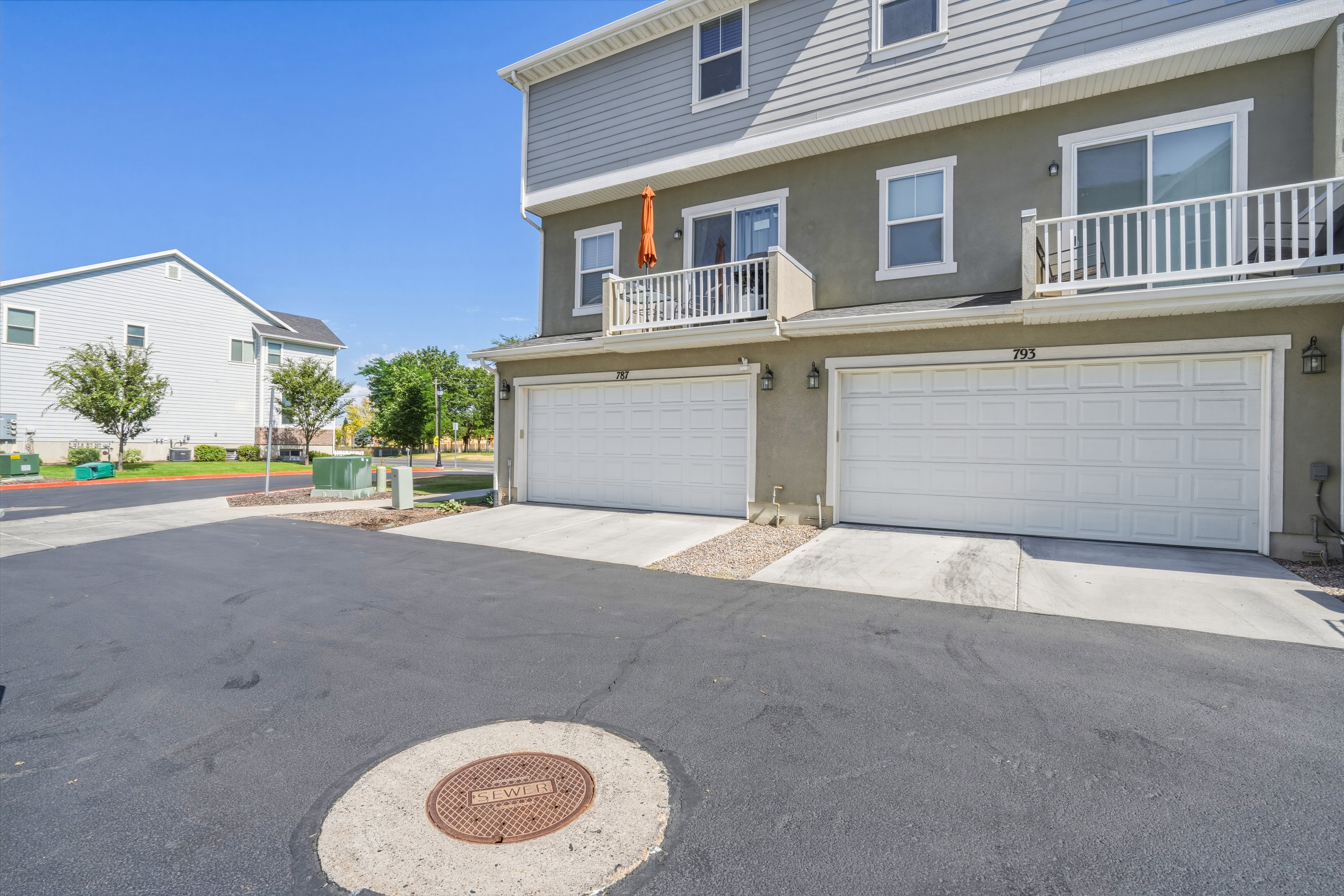 Contemporary townhome exterior featuring light gray siding and stucco finishes