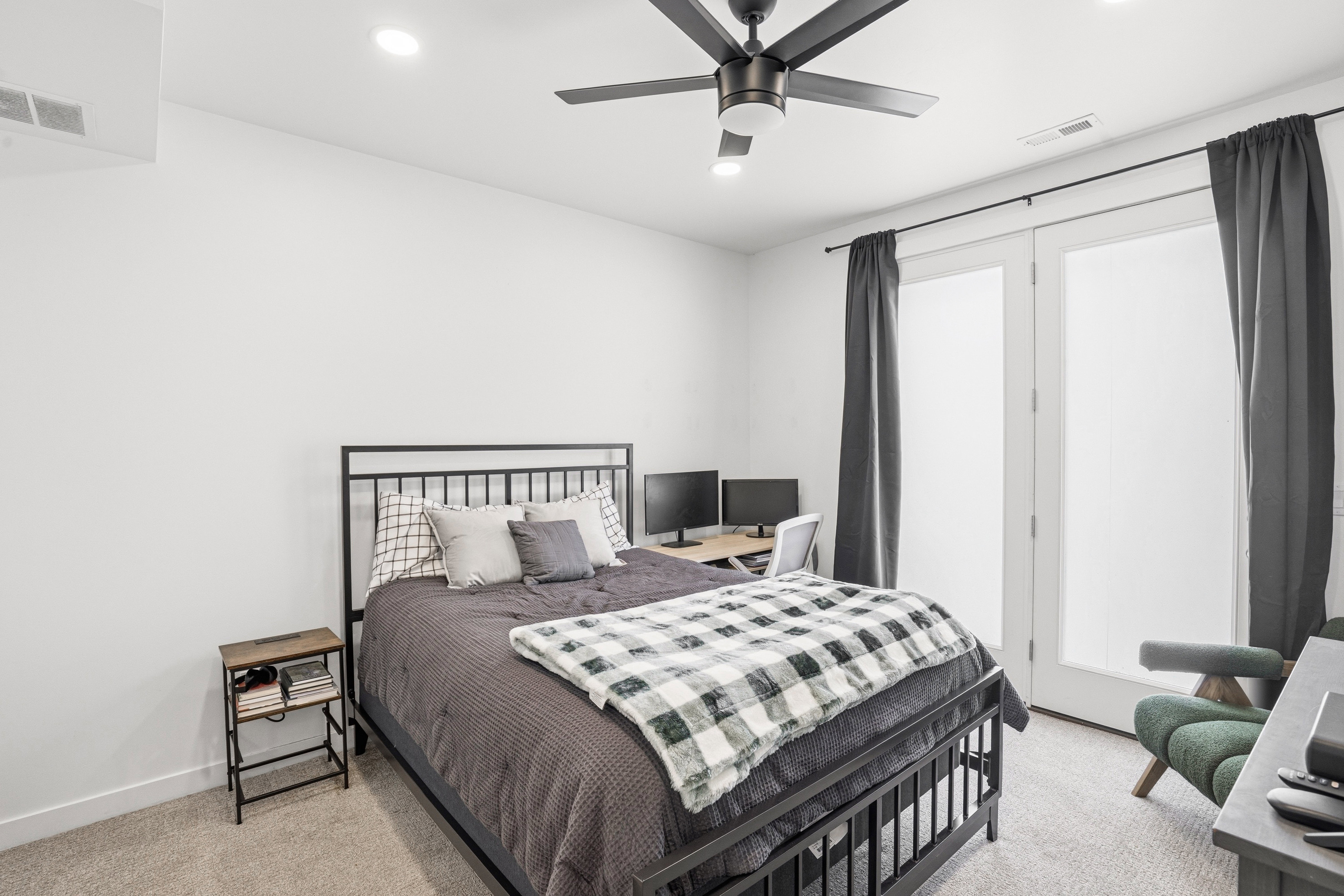 Spacious room featuring light-colored carpeting, a black ceiling fan with integrated lighting, recessed lighting, and white walls