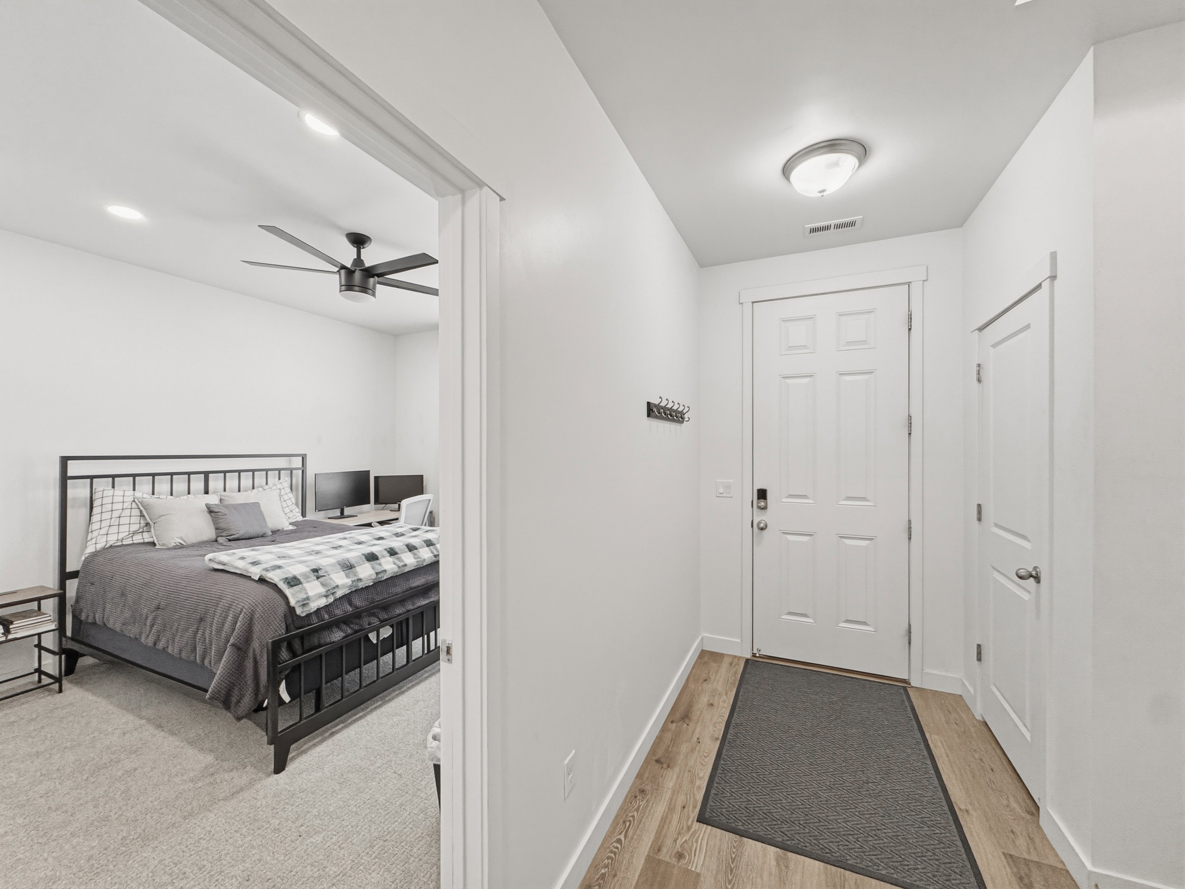 Entryway featuring wood-finish flooring, a white paneled door with modern hardware, and a flush mount ceiling light
