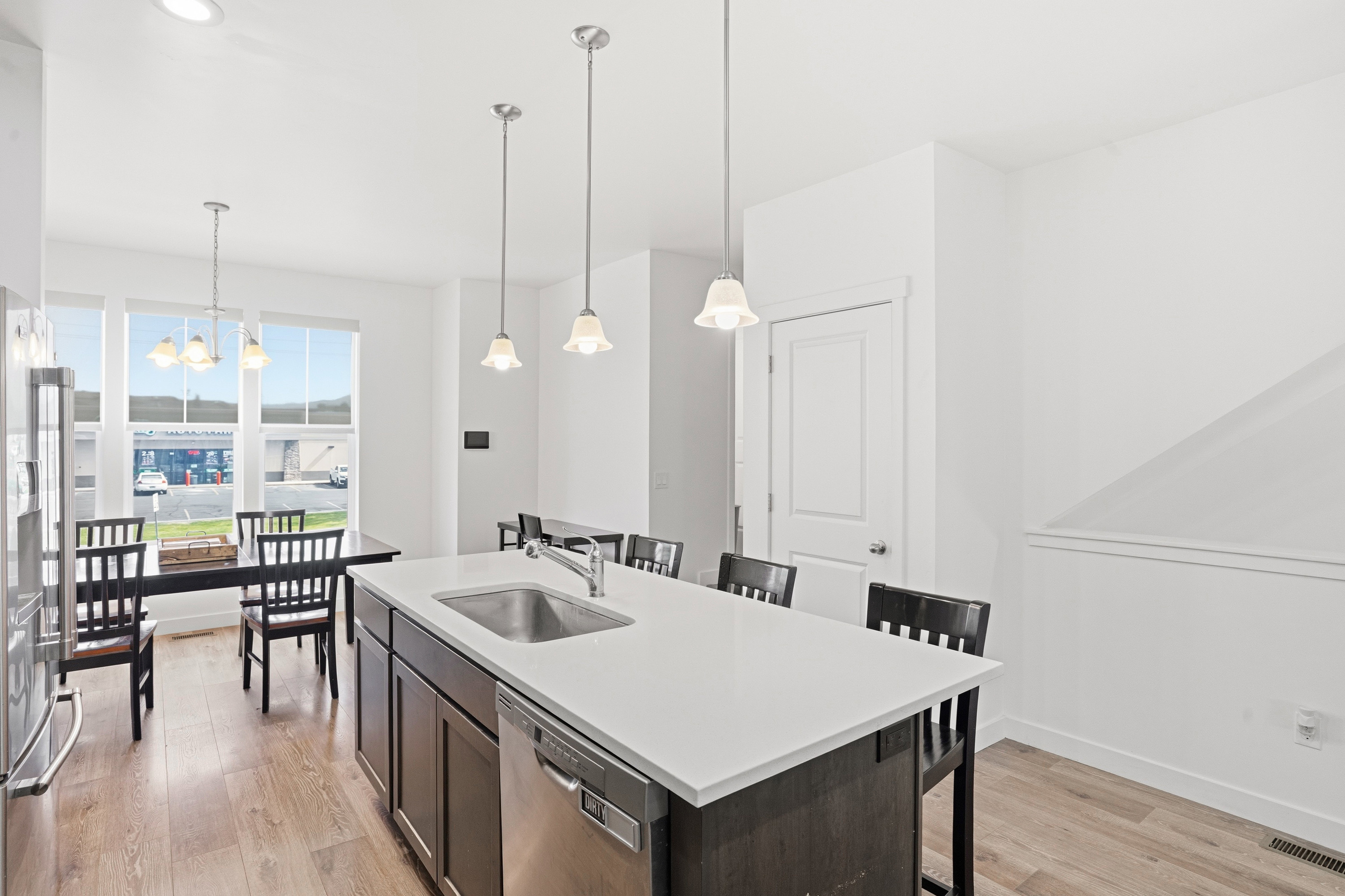 Contemporary kitchen island with an undermount sink, integrated dishwasher, and white countertop