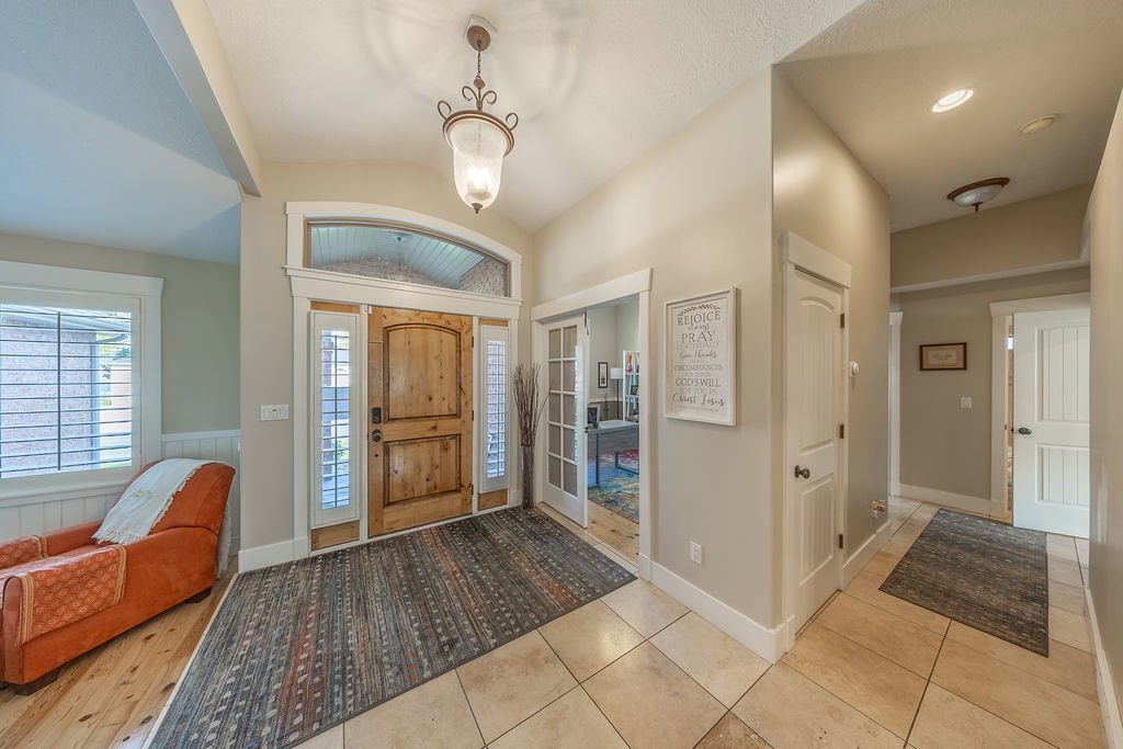 Inviting entryway featuring a wood front door with sidelights, transom window, and a decorative pendant light