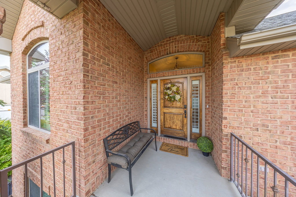 Brick exterior with a prominent arched window and a wood-paneled entry door