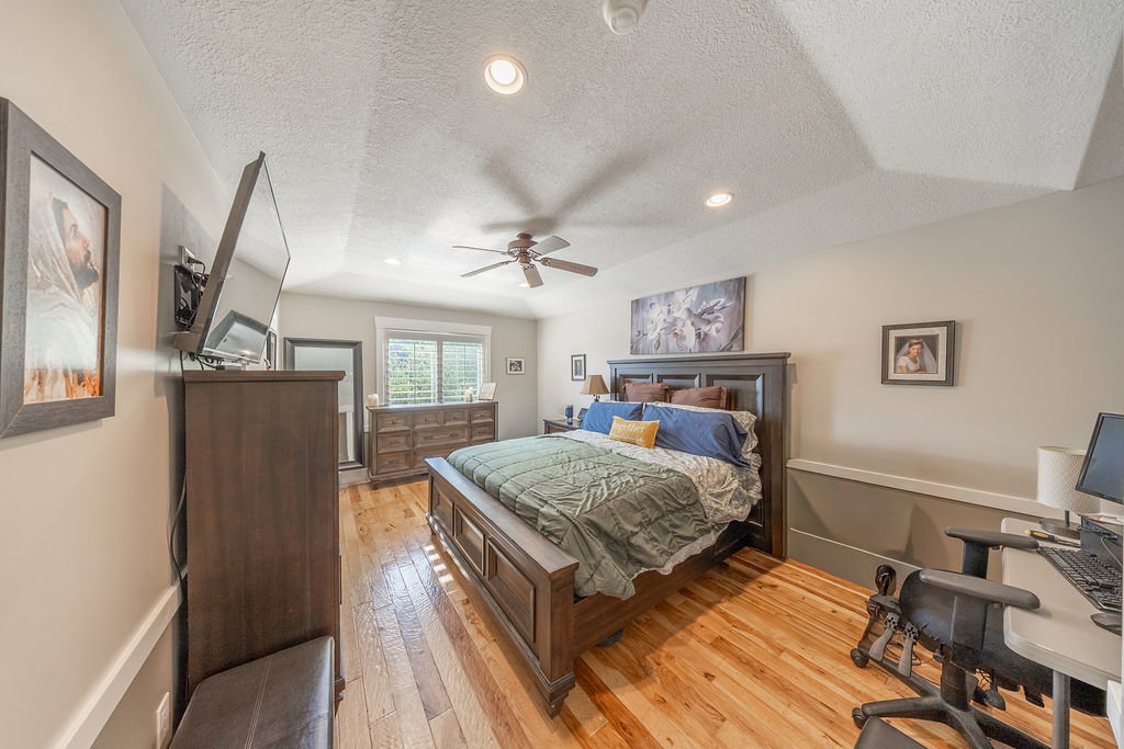 Spacious room featuring wood-finish flooring, a vaulted ceiling, and recessed lighting