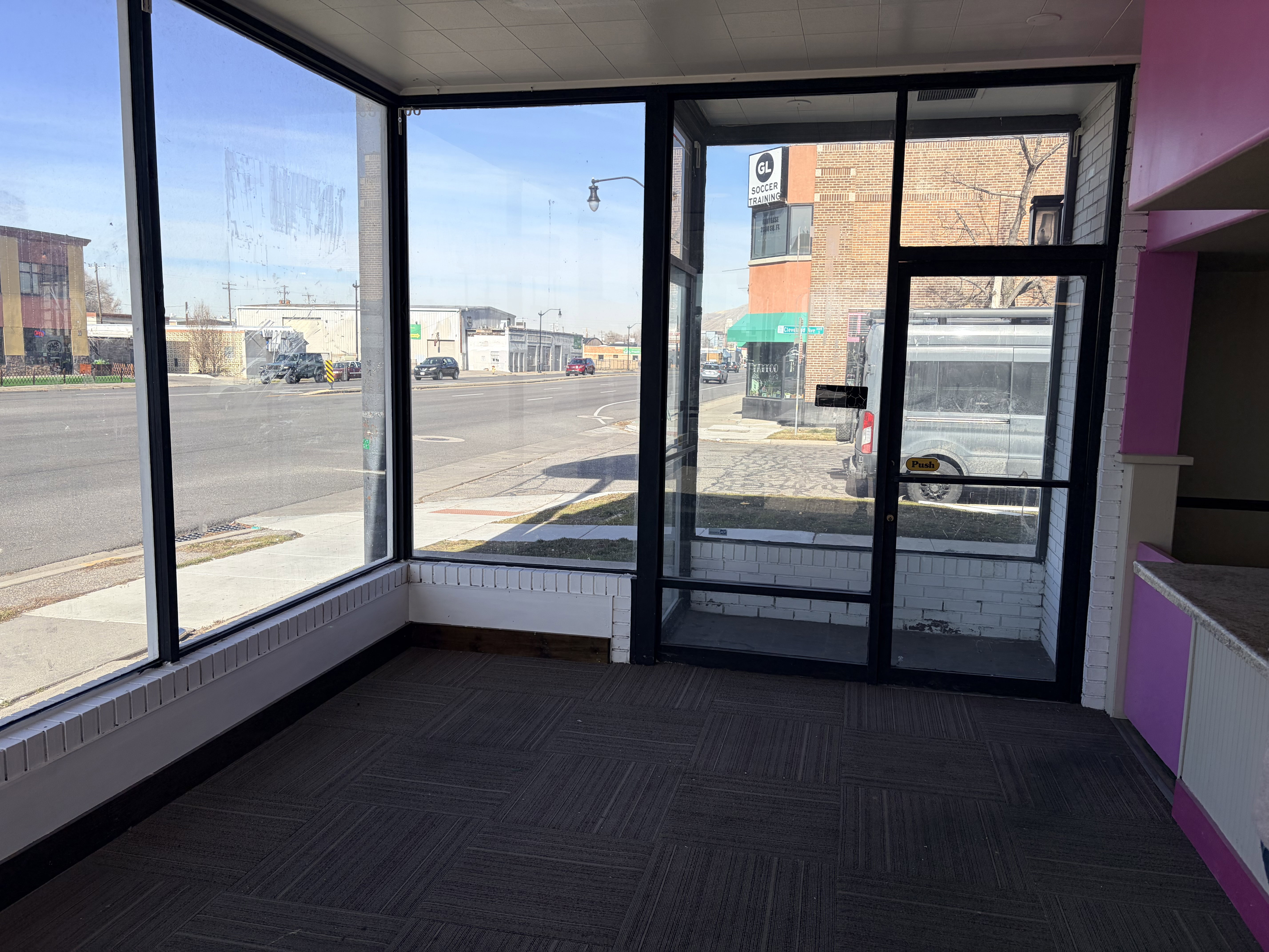 Expansive storefront windows featuring dark framing and an integrated glass entry door