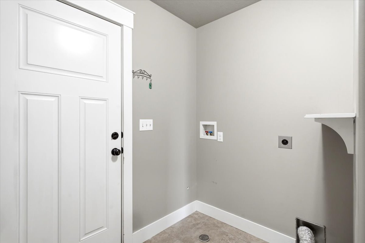 Dedicated laundry area featuring light gray walls and durable flooring