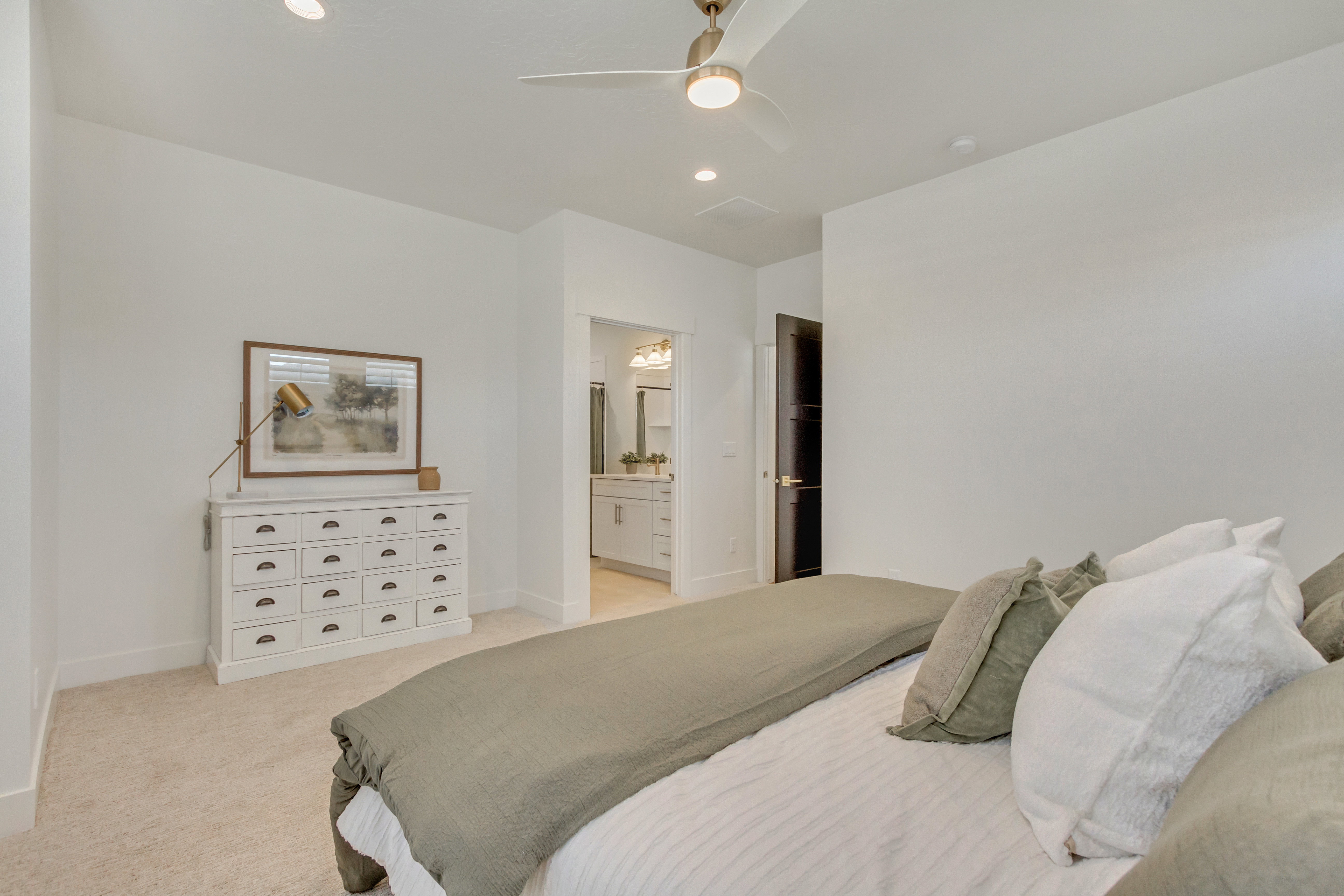 Spacious bedroom featuring plush carpeting, a modern ceiling fan with integrated lighting, recessed lighting, and a dark wood-finish interior door