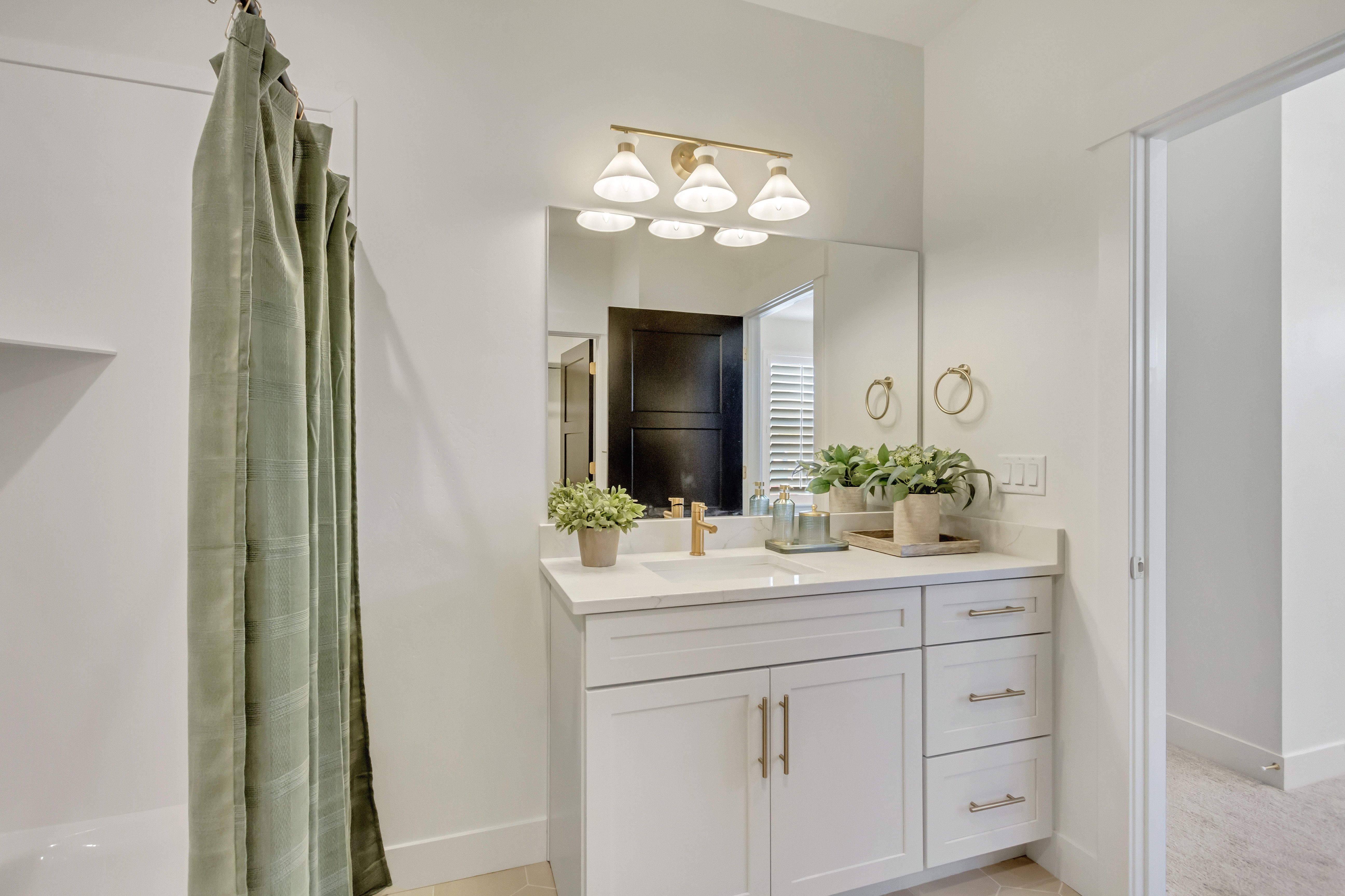 Bathroom featuring a white vanity with gold-finish hardware, a rectangular undermount sink, and a light-toned countertop
