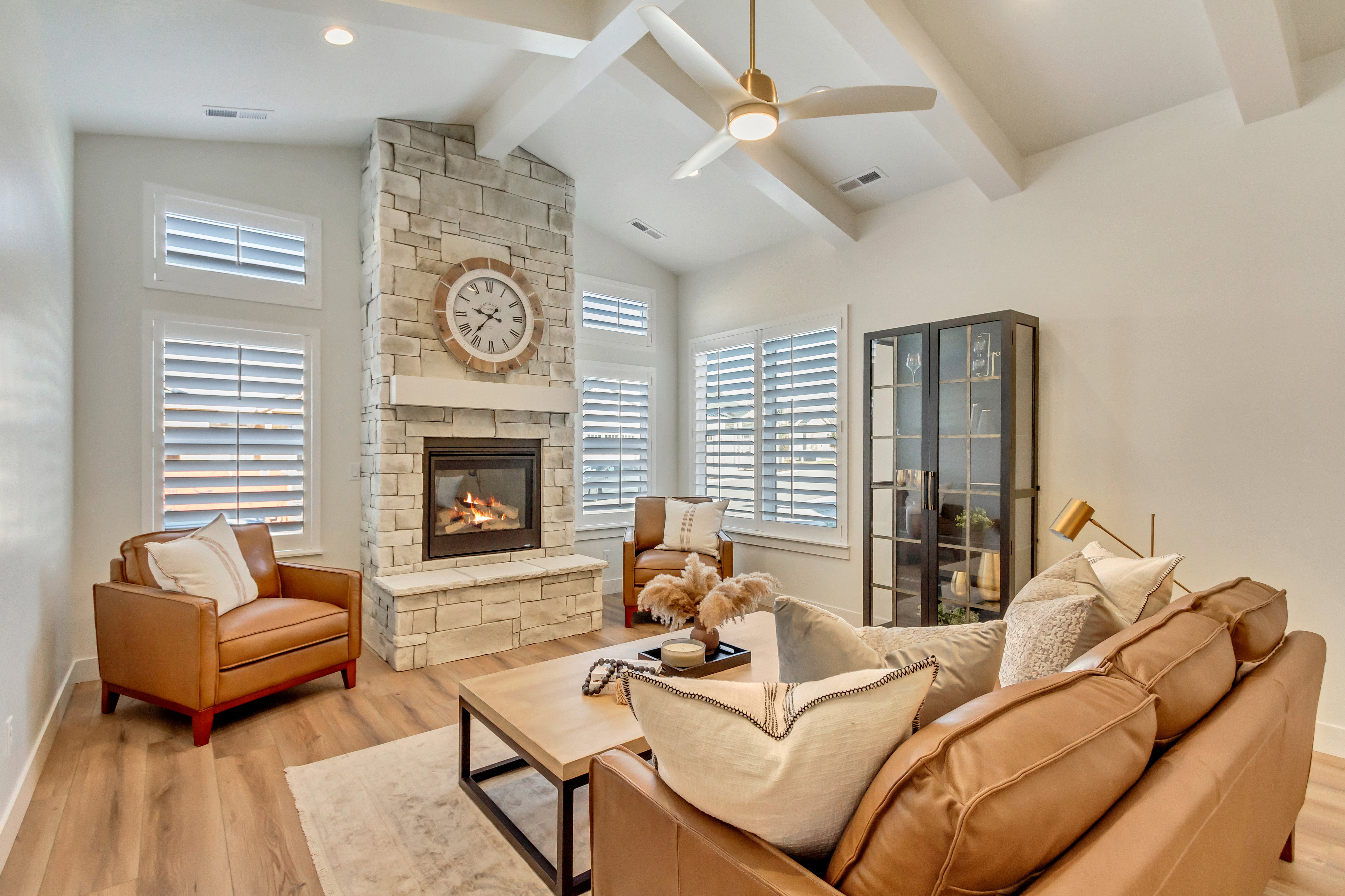 Great room with a stone-clad fireplace and wood-finish flooring