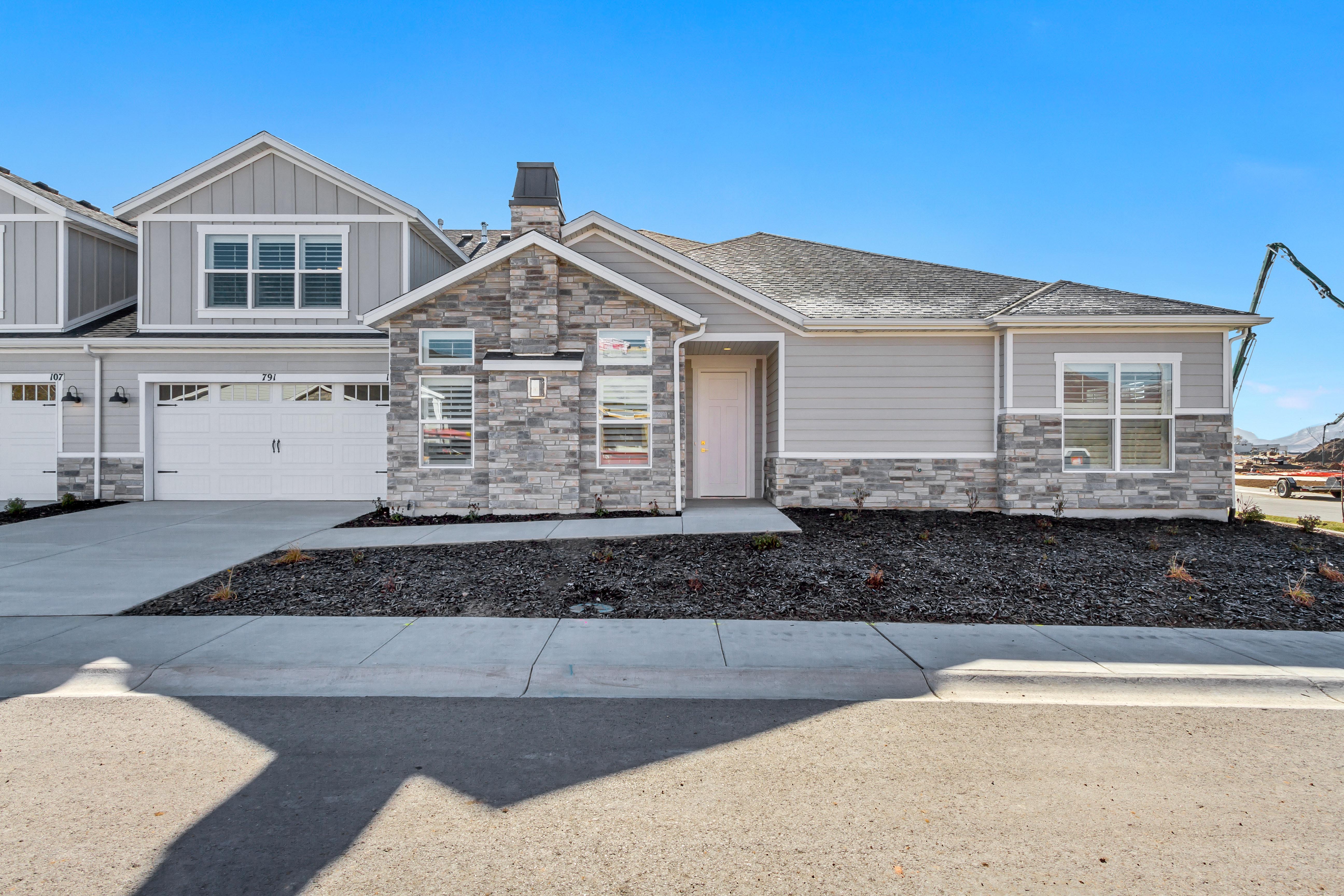 Contemporary exterior featuring a stone facade and light gray siding