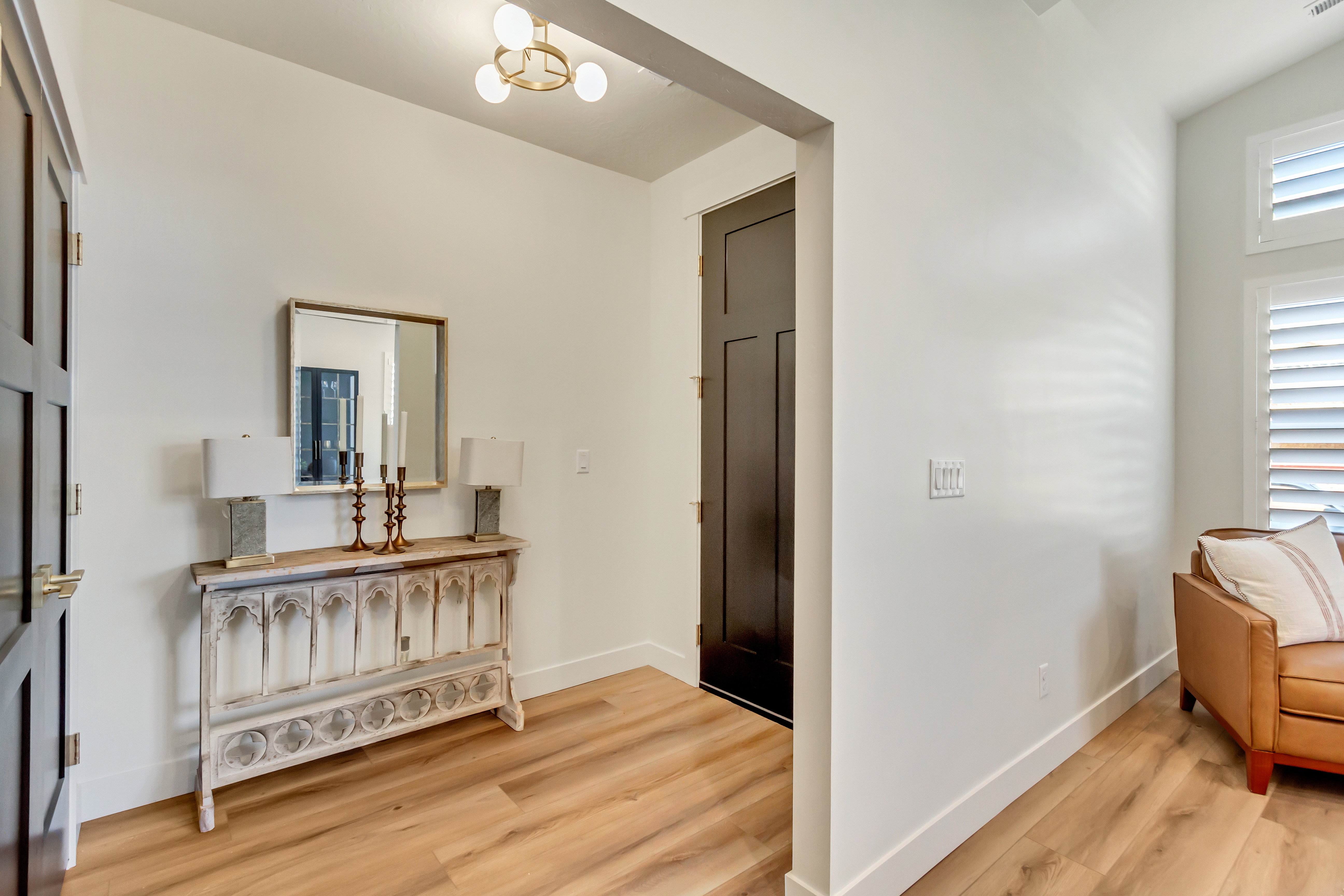 Entryway featuring wood-finish flooring, white baseboards, and a modern brass ceiling light fixture