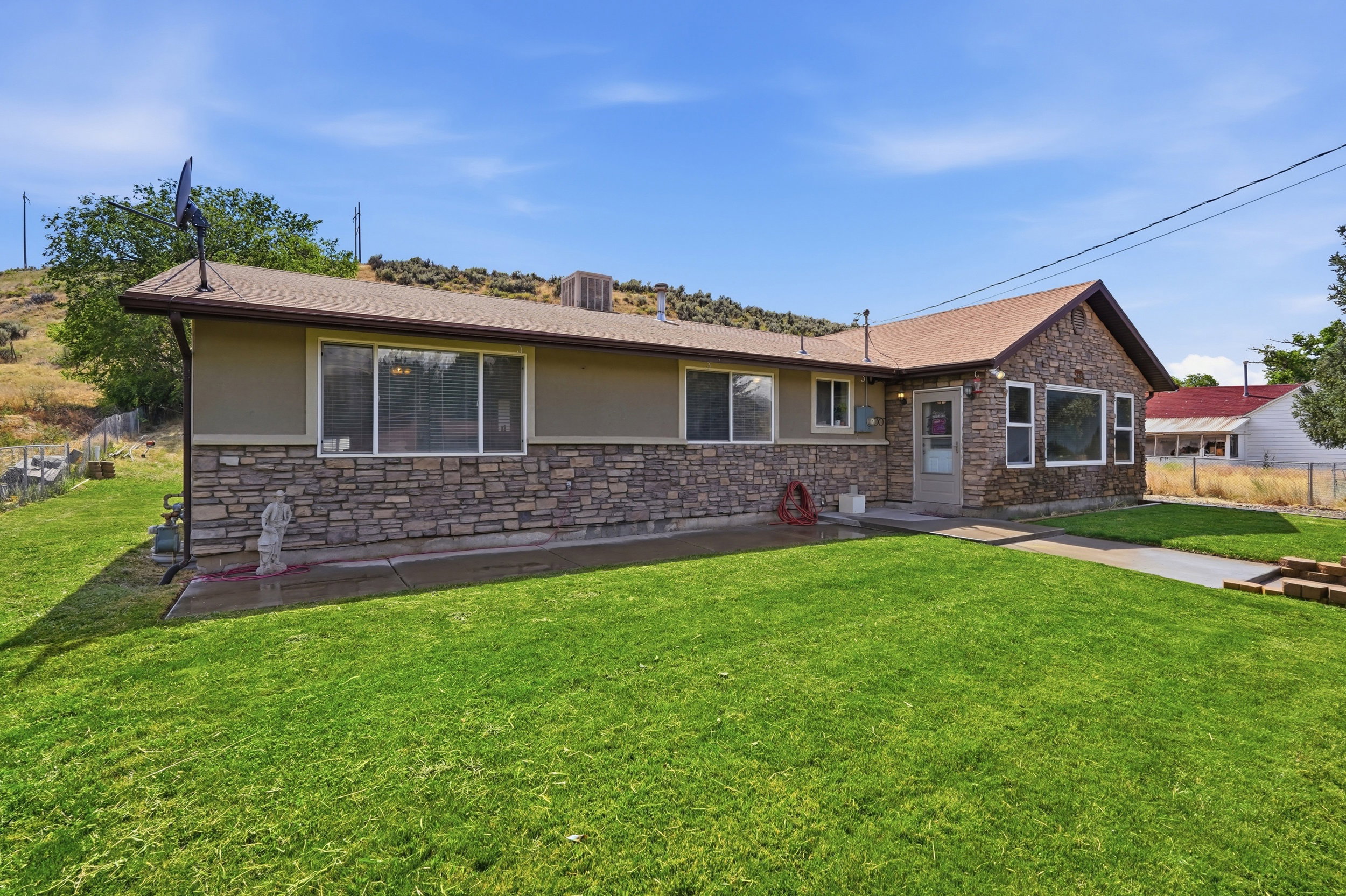 Ranch-style exterior with stone veneer accents and tan siding