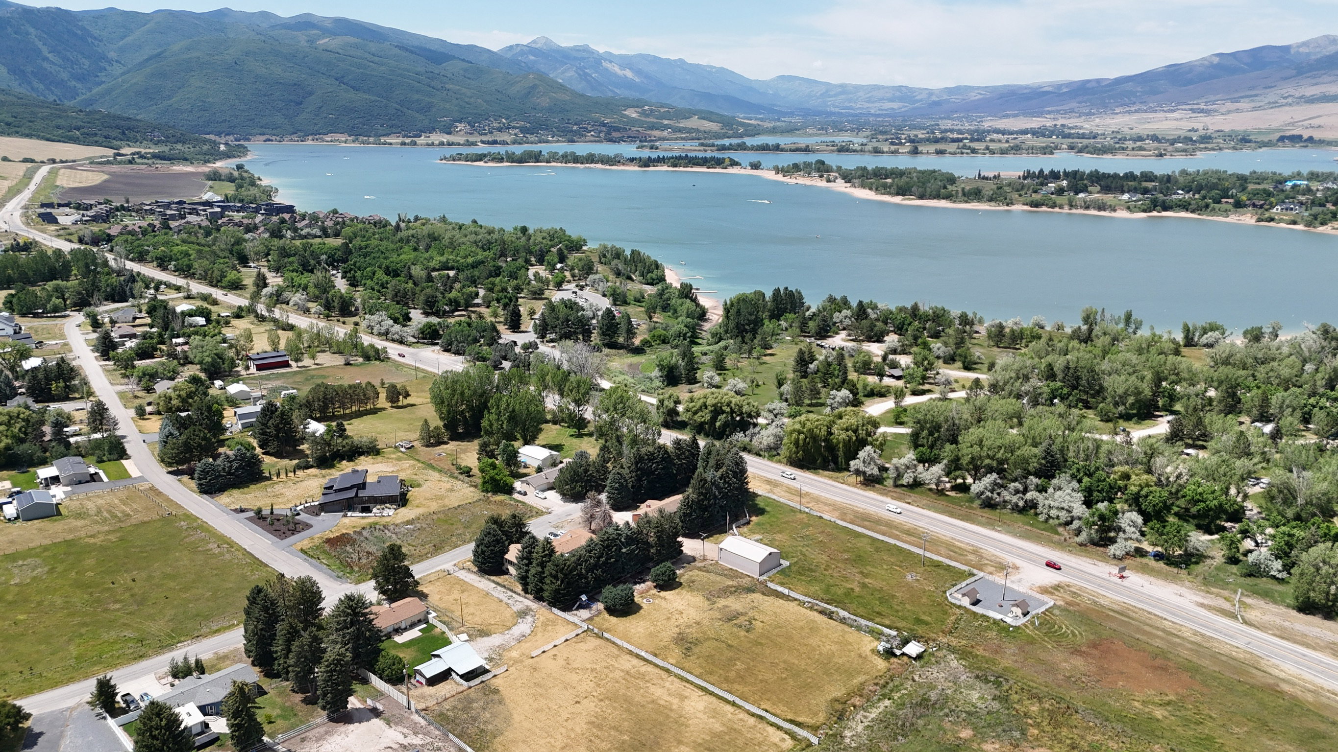 Expansive aerial perspective showcasing a lake with surrounding natural landscapes and distant mountains