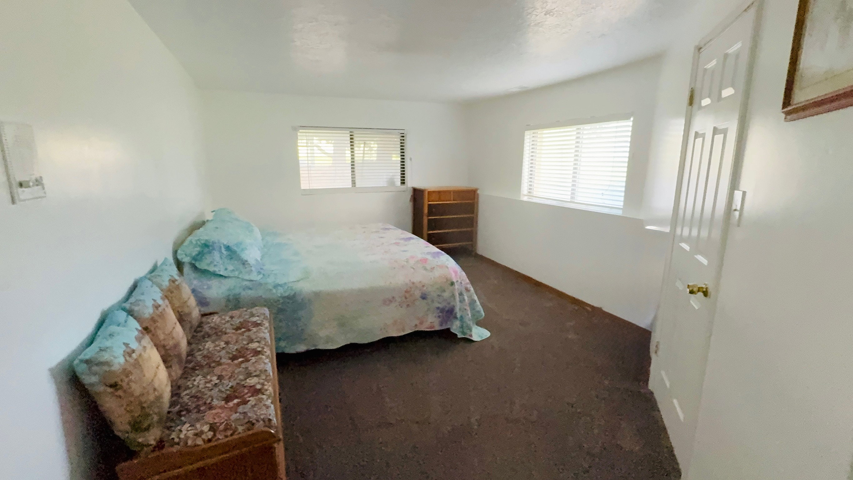 White painted walls with two windows featuring horizontal blinds