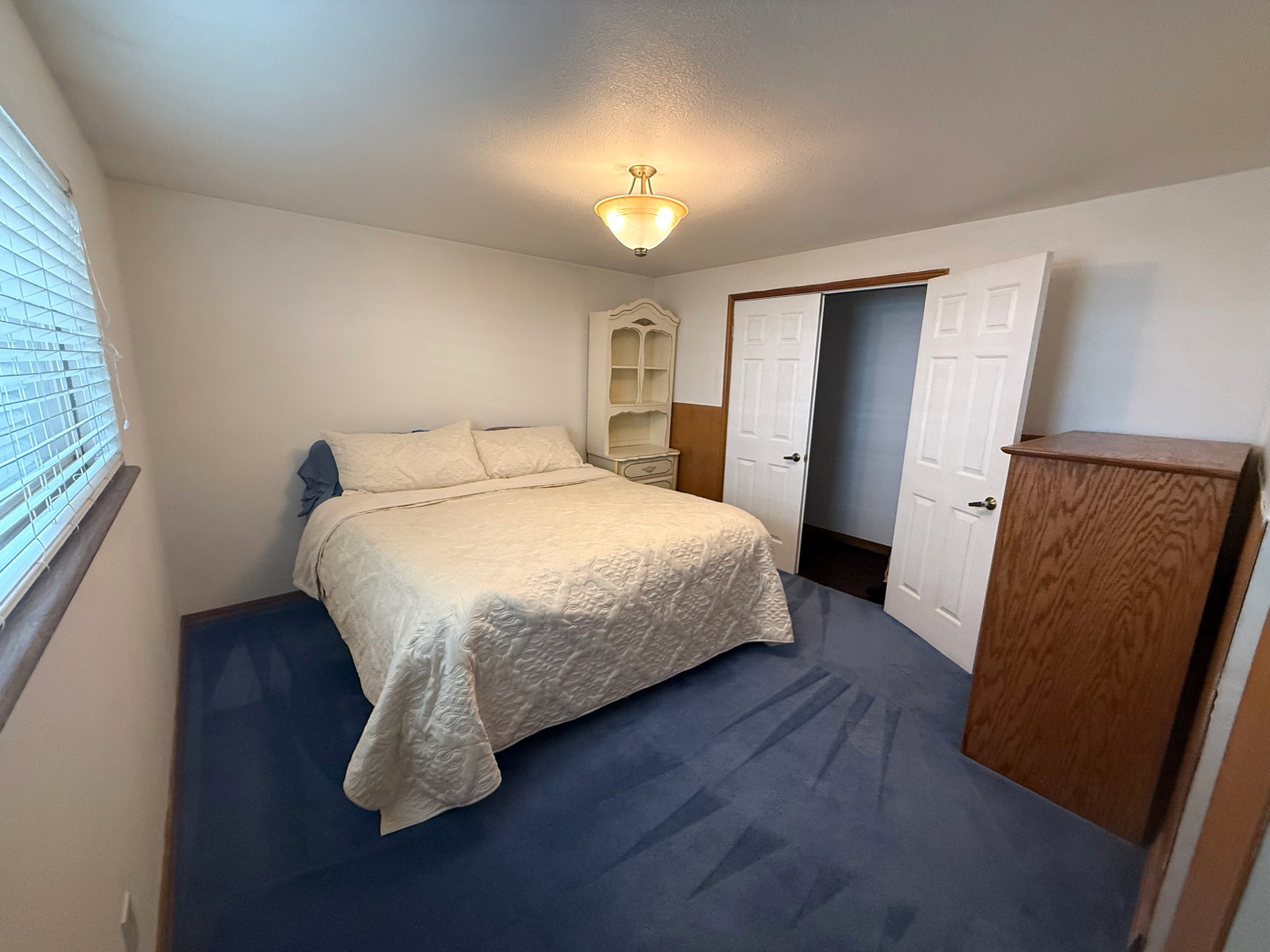 Bedroom featuring blue carpet and white walls