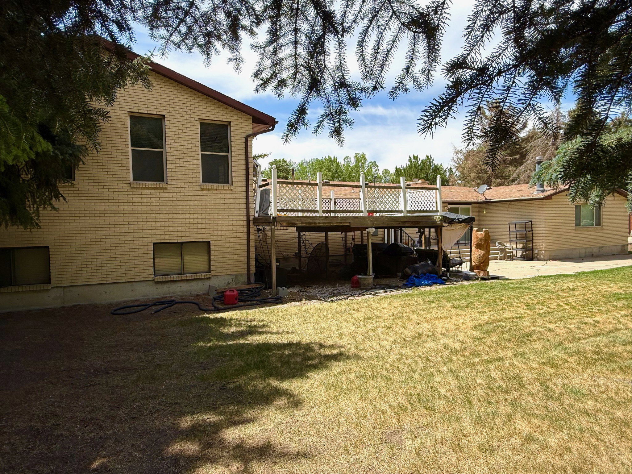Expansive backyard featuring a multi-level deck, a lower patio area, and a brick exterior