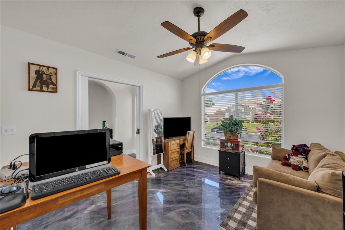 Arched window with slat blinds, wood-finish ceiling fan with integrated lighting, and high-gloss flooring
