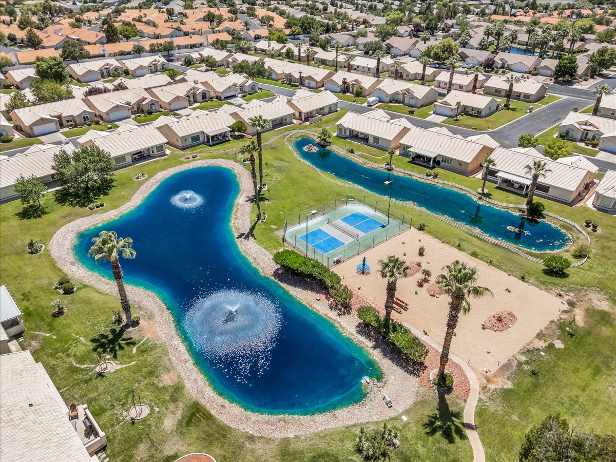 Expansive community featuring multiple bodies of water with fountains, mature palm trees, and manicured green spaces