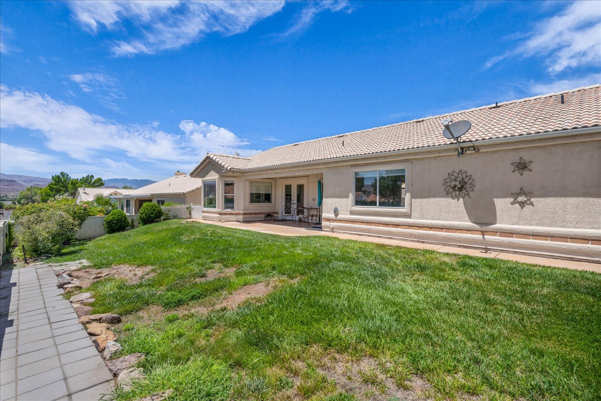 Rear exterior featuring a tiled patio, stucco siding, and a tile roof