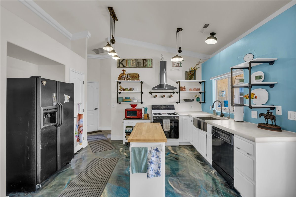 Modern kitchen featuring white cabinetry, a black appliance suite, and a farmhouse sink
