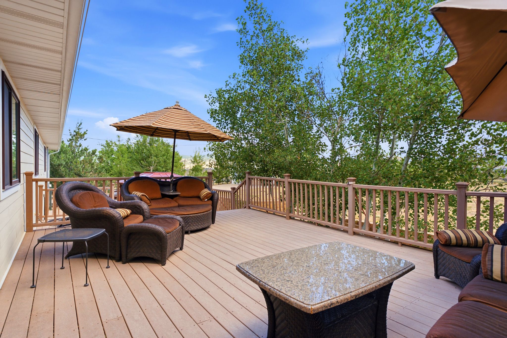 Expansive outdoor deck featuring wood-finish flooring, wood railings, and ample space for furnishings