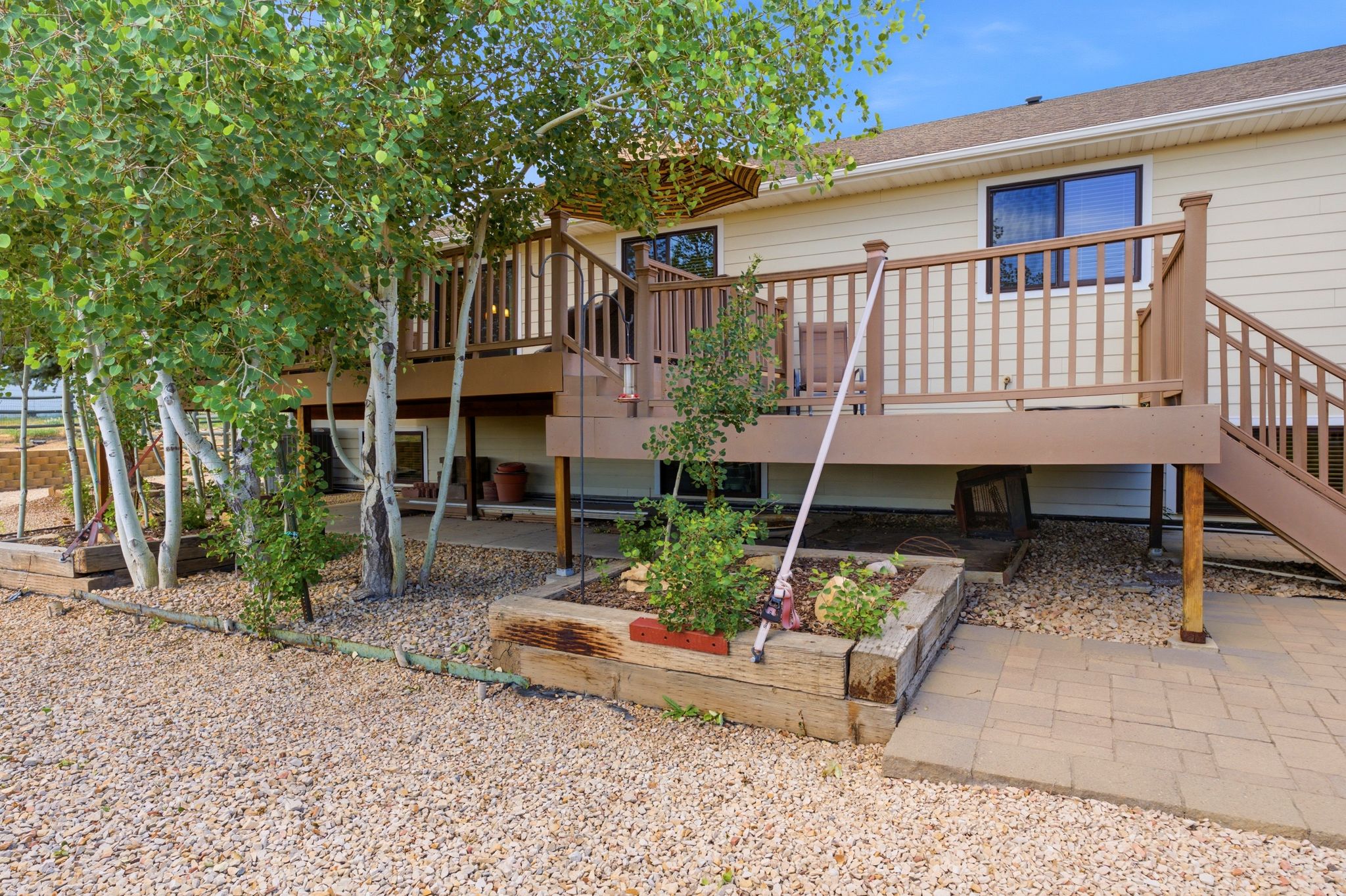 Two-story residence featuring a ground-level patio with an upper-level deck