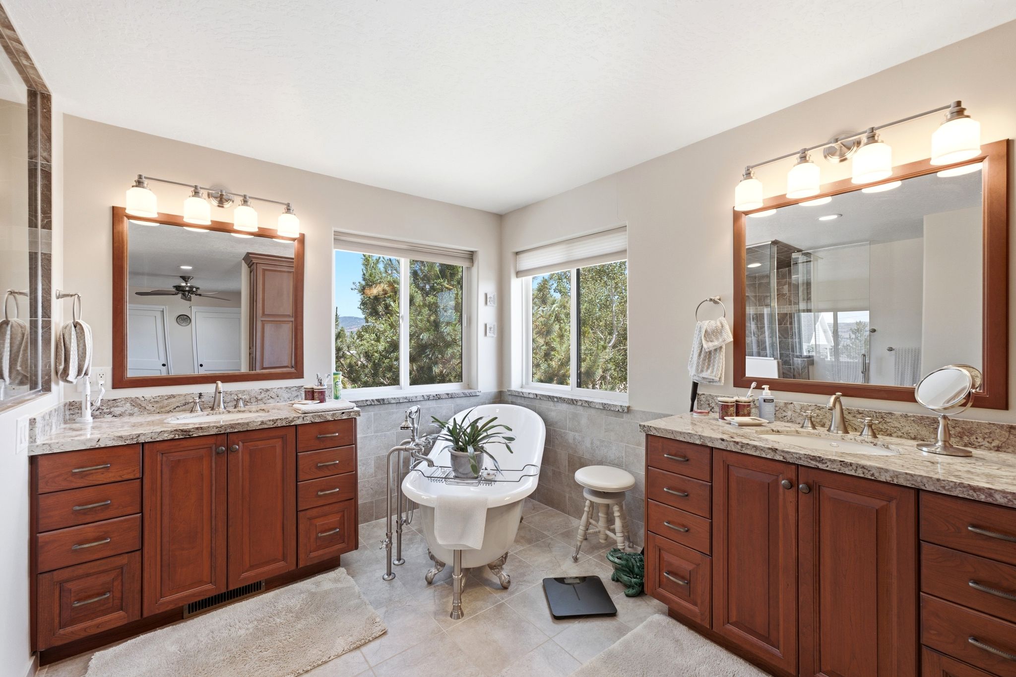 Freestanding clawfoot tub with a tile surround and dual windows