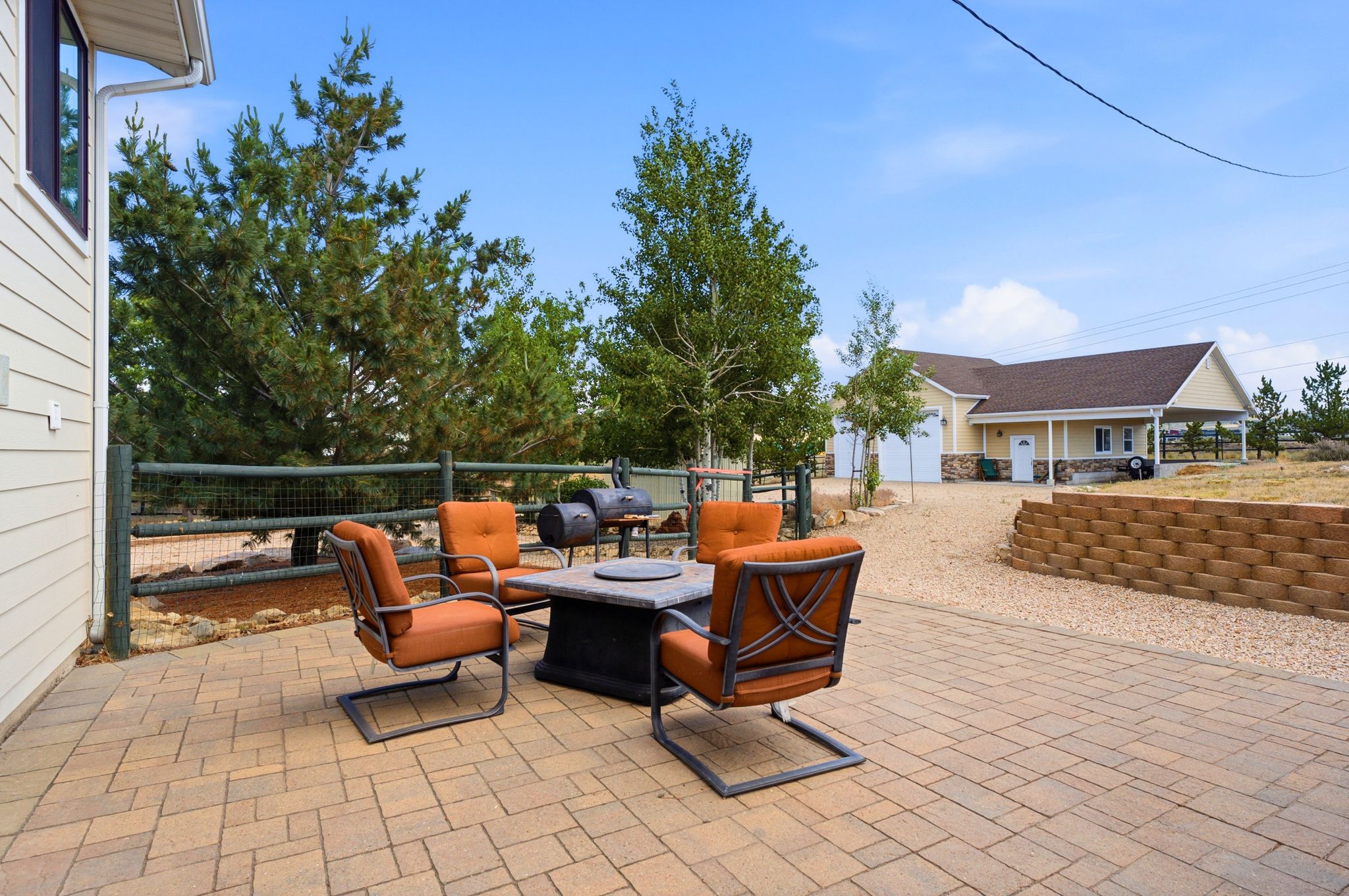 Expansive paver patio with a stone fire pit table