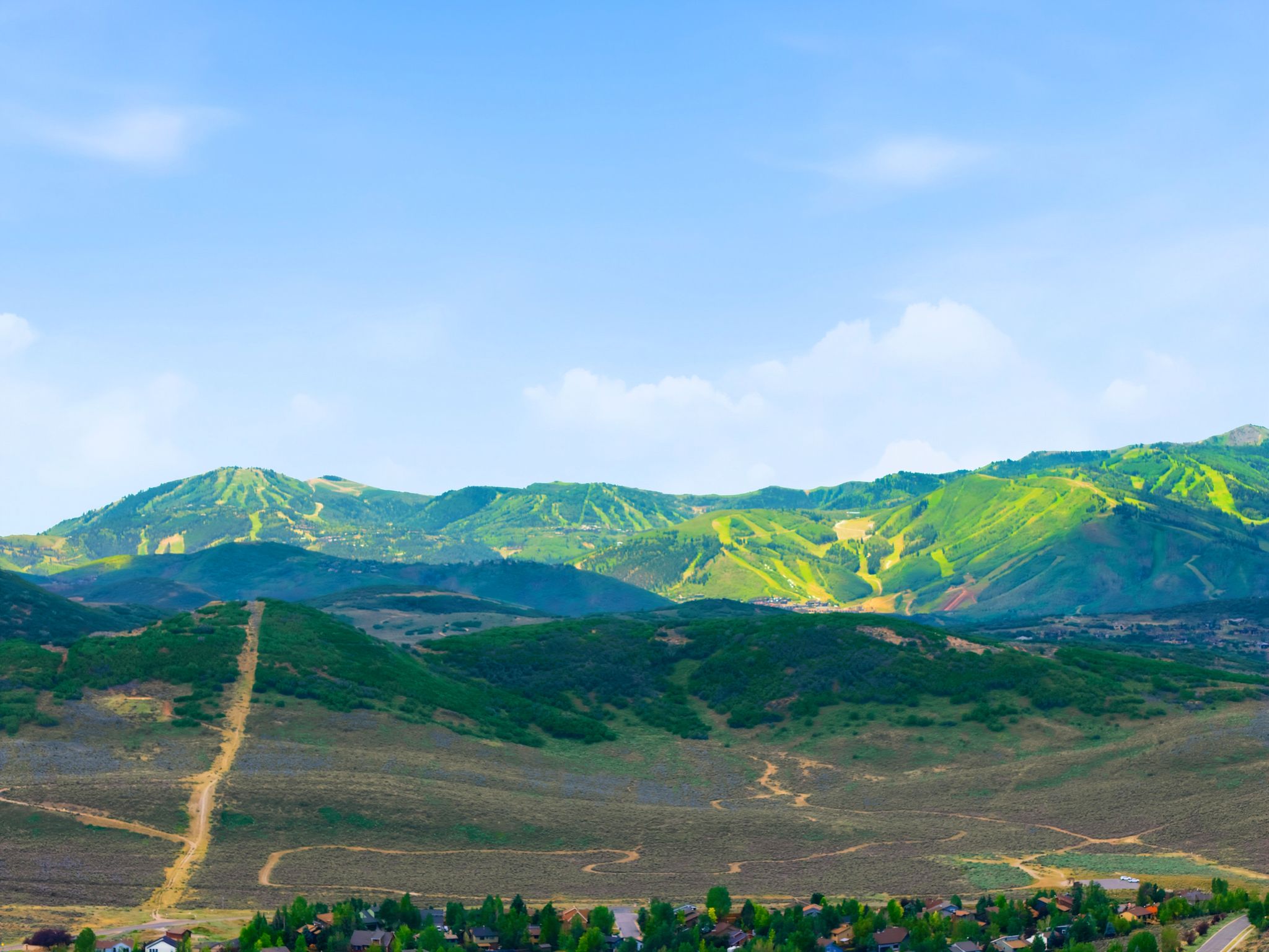 Expansive mountainous landscape featuring green valleys and distant peaks