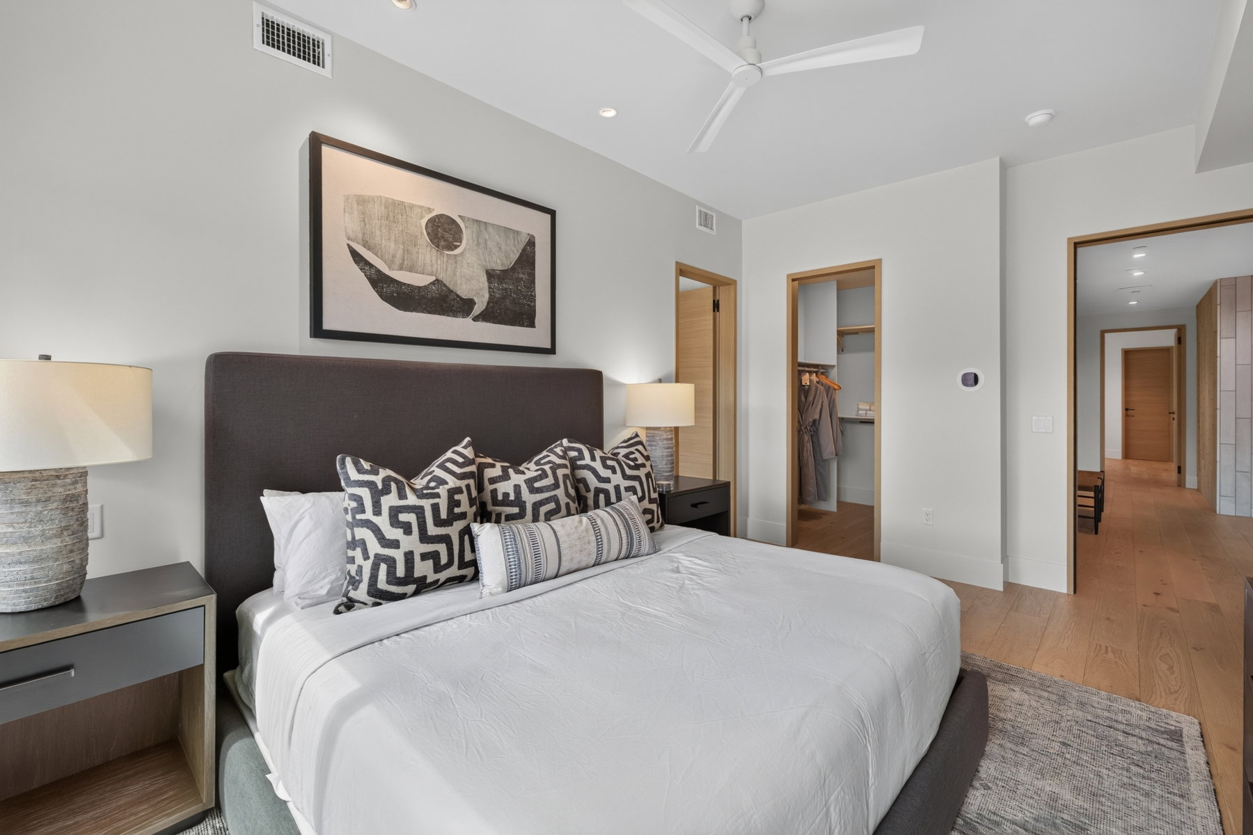 Well-lit interior room featuring light wood-finish flooring, a contemporary ceiling fan, and recessed lighting